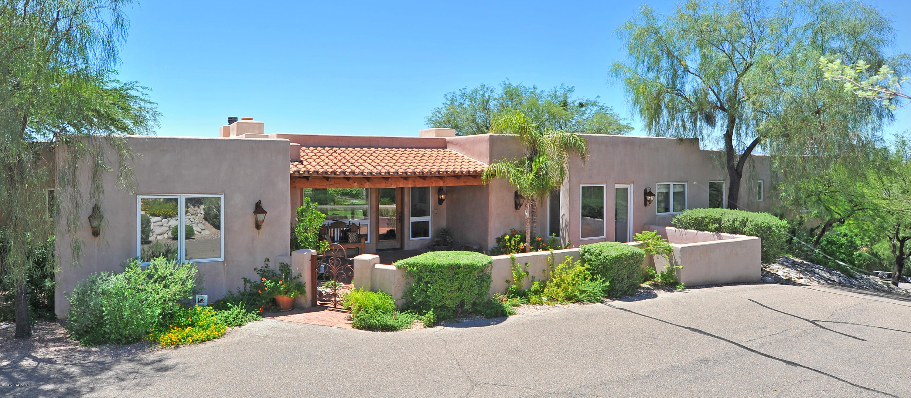Seller is willing to accept or counter offer w/ in the range price of 950k-985k. Best value you will find in the Foothills! Stunning Arizona Hacienda on 1.1 acres w/ city & mountain views, located in prestigious gated Hacienda Del Sol Estates. Spacious living room & family room/kitchen both open into the long, travertine-paver patio featuring: pizza oven, BBQ, bar, grassy lawn & therapeutic salt-water pool and spa. Master wing situated next to 5th bedroom/den, master suite with 2 walk-in closets, private washer/dryer & spa tub looking out to the city lights, Children's wing features 2 bedroom and study desk area and guest suite. Beautiful amenities include a gourmet kitchen with large center island, polished concrete floors, corbels and wood beams. Very large 3 car garage and storage area