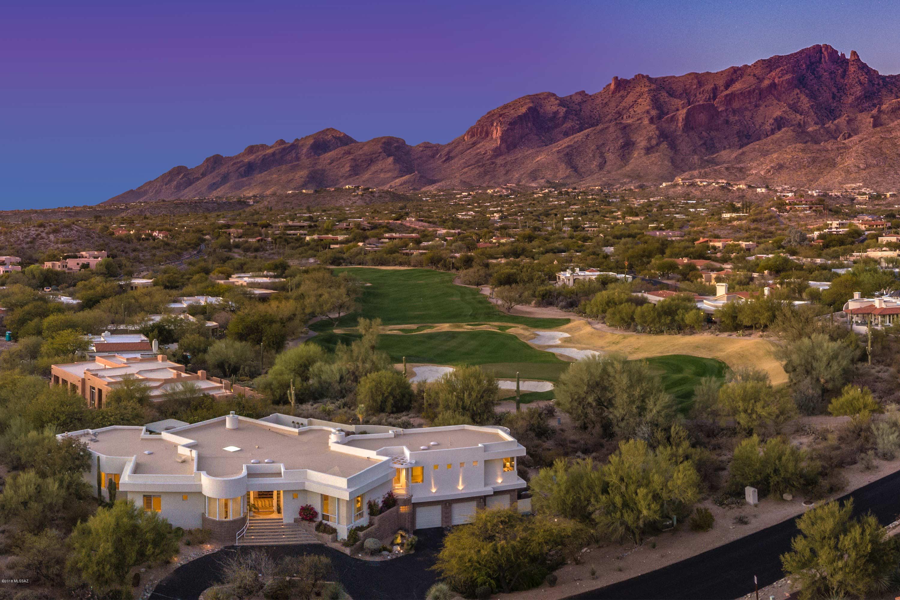 Majestic mountain and golf course views flourish throughout this meticulously-maintained home. Feel the contemporary elegance at La Paloma Estates. Excellent floor plan, large private, professionally landscaped backyard area with pool and spa, perfect for entertaining guests. This 4 bedroom, 4 bath home offers a large den/library, wet bar, workout room, and an office area. Gracious custom upgrades and appointments throughout this estate. The kitchen offers granite countertops and stainless steel appliances. The master retreat includes spacious closets, a den area, oversized master bathroom, master terrace, and mountain views! Tucson Foothills living at its finest.