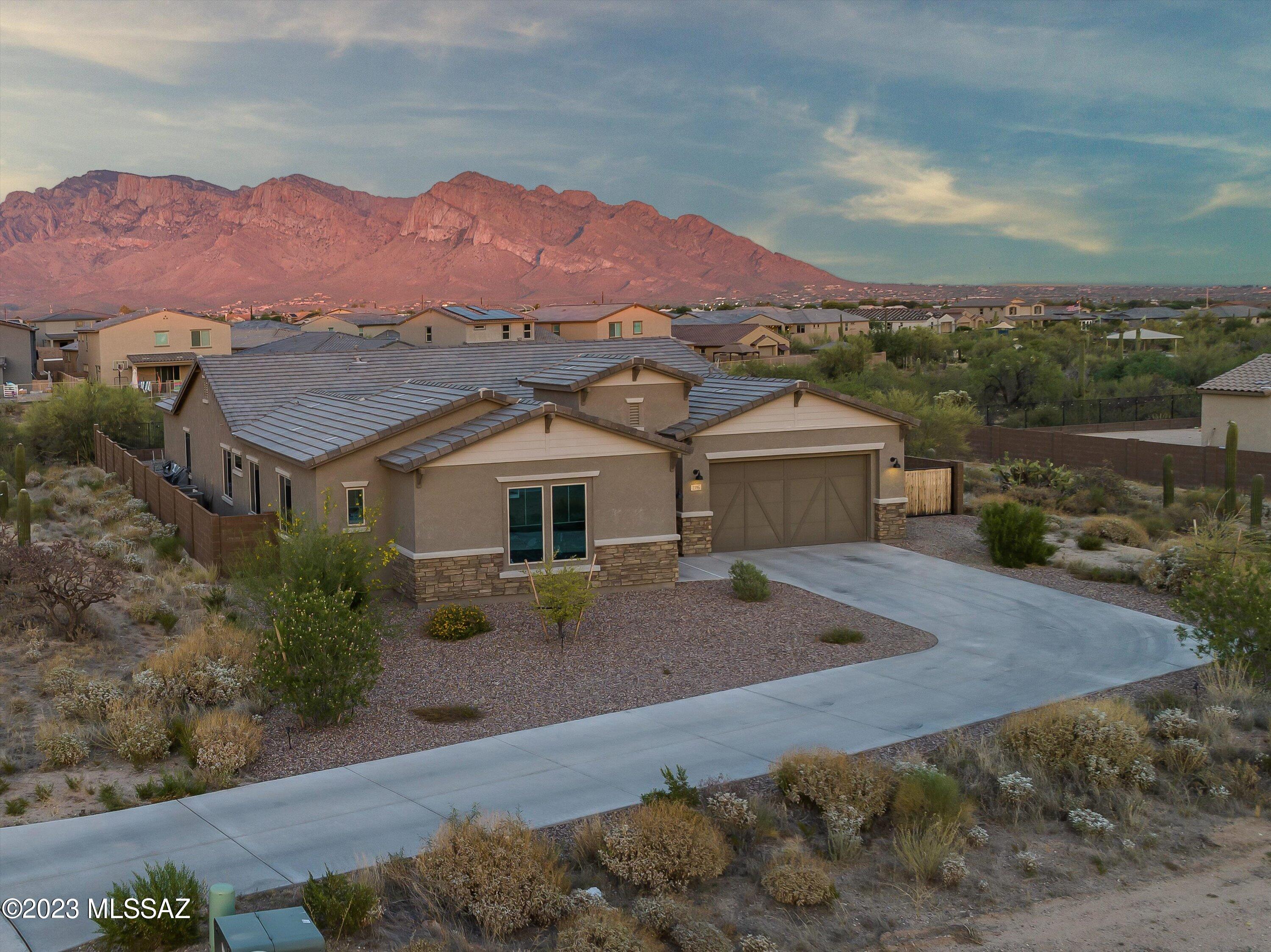 Better than new construction! Exquisite gated community in Oro Valley! Home boasts 4 BR, 3.5 Baths, 3-Car Garage, Office + Flex Room. The owners customized this 2021 home w/ custom hard wood and tile throughout the entire home, great room, additional insulation in walls for sound proofing, 12' RV side gate, view fencing and more! 4th bedroom has an ensuite bathroom. Kitchen: QUARTZ counters w/oversized island, white staggered cabinetry,  gas cook top, double ovens & an amazing walk-in pantry. HUGE Laundry room with sink + numerous custom cabinets. Primary bath: custom shower w/ walls of tile, two vanities, soaking tub, + a closet built for royalty. Glorious Views of the Catalinas from from your large covered patio. Entertainer's Paradise. Walk to school + close to shopping