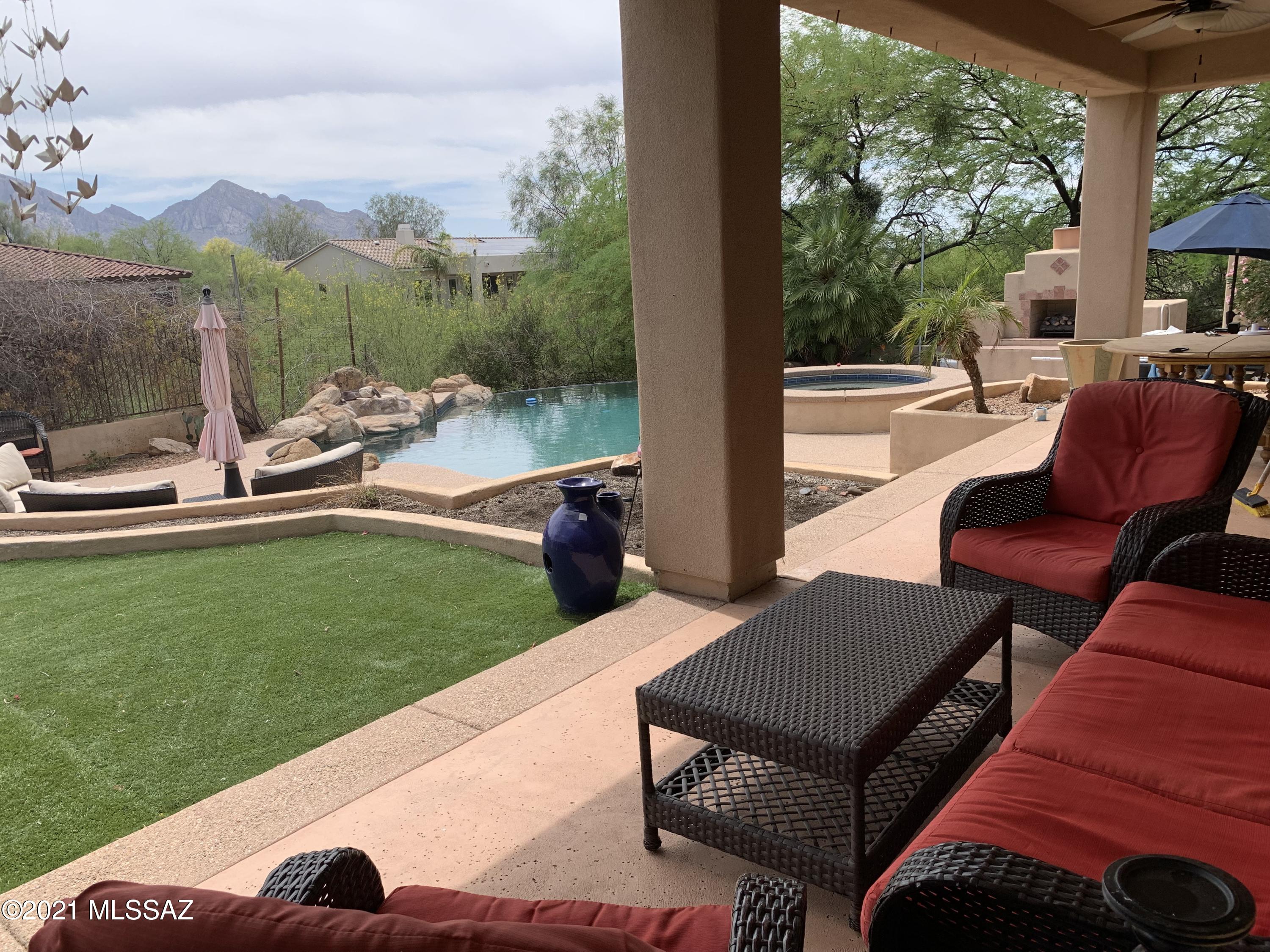 This beautiful Oro Valley Vistoso  Ridge community home is located on a rare .99 acre corner lot with spectacular Catalina Mountain Views. This four bedroom 3 1/2 bath home includes one bedroom that can be used as guest Casita with separate entry and full private bathroom. Entertain in this amazing outdoor living space with heated pool and spa, Ramada featuring built-in barbecue and sink. Also enjoy outdoor gas fireplace and gas fire pit along with large covered patio. Gourmet kitchen offers excellent storage with granite counters and backsplash, built in desk, large island, warming drawers and much more. In home office/den offers custom built in desk and bookshelves. Retire to the master suite with magnificent views overlooking the sparkling pool and mountains. Soak in the Jetted tub featured in the master bathroom. Plantation shutters throughout this home and beautiful entry fountain in Courtyard add to the charm of this Oro Valley gem. Must see soon won't last long!
(Sqft includes guest quarters.)