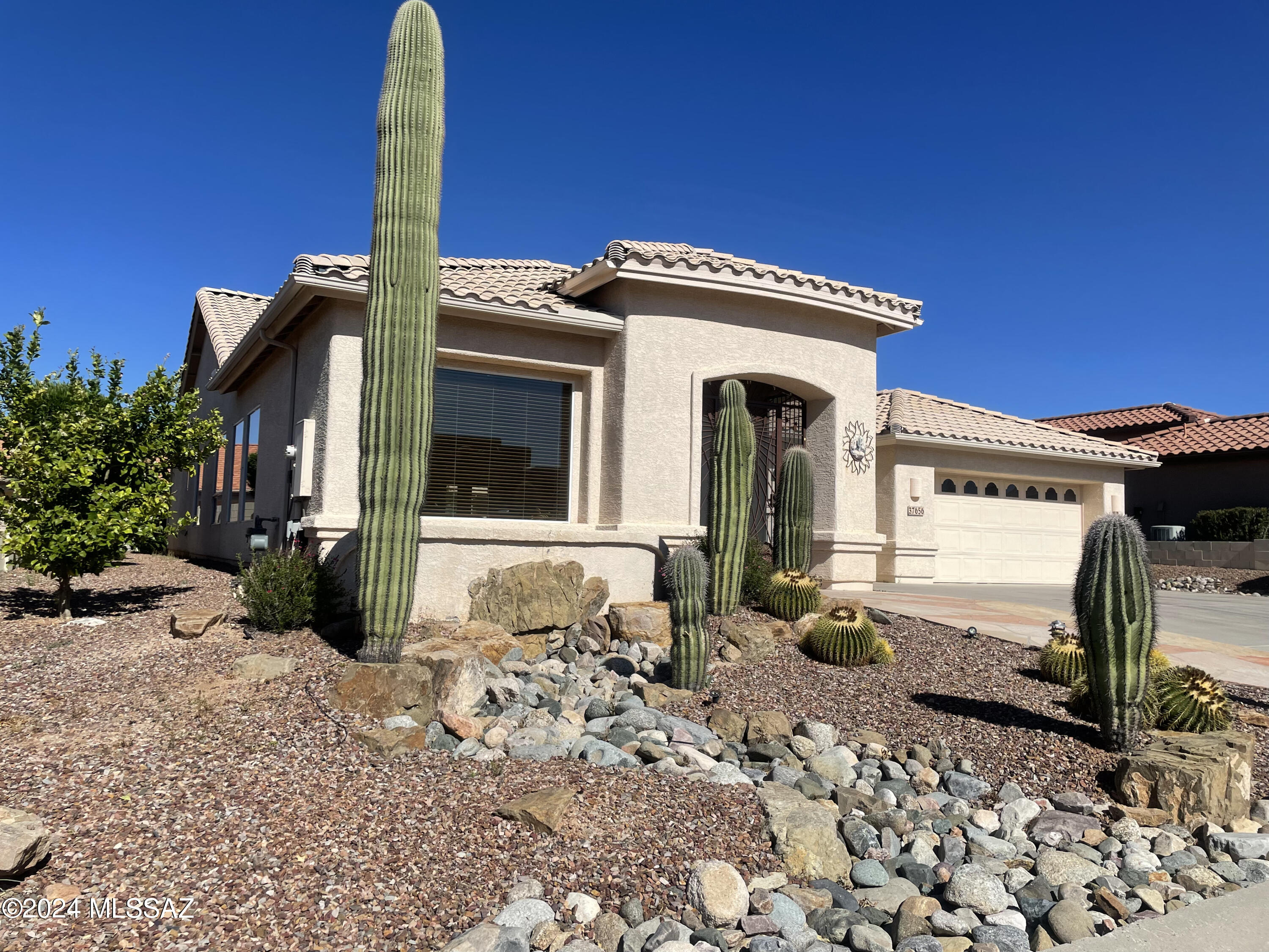 This beautiful 2005 CHEYENNE model home has a spacious 2,783 Sq Ft, 3 bedroom, 2 full & 1/2 bath & 3 car garage. Foyer leads to den/office with built-in bookshelves and vaulted ceilings. The sitting and formal dining room area allow for large family gatherings with gorgeous views of the Catalina Mountains. Open concept kitchen has engineered stone countertops with black GE electric appliances with stainless steel refrigerator. Family room has oak built-in entertainment center with space to accommodate a large screen TV. Owners suite has upgraded wood flooring plus dual walk in closets each with built-ins for added storage space. Full length covered back patio features gas line for BBQ. Front patio has small seating area with spectacular views of the Catalina Mountains.