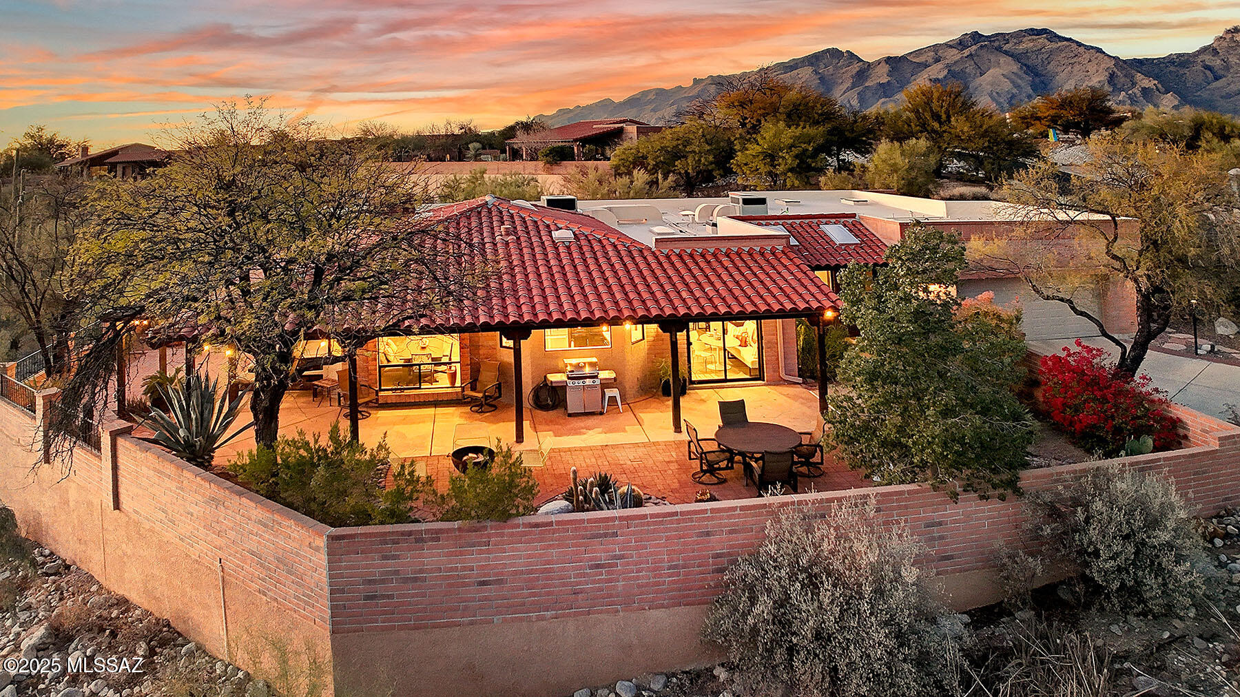 Nestled on a quiet cul-de-sac, this elegant home offers an unparalleled combination of privacy, luxury, and breathtaking views. From its expansive city lights to the endless mountain vistas, this property provides a serene backdrop for a lifestyle of comfort and sophistication. Completely remodeled with the finest materials, this home boasts a fresh stylish feel, featuring new windows, doors, skylights, and stunning new flooring throughout. The custom interior design includes newly textured walls, rounded corners, and many thoughtful details that elevate the living experience.The heart of the home is the exquisite, custom-designed kitchen. With new cabinetry, sleek quartz countertops, and top-of-the-line Bosch, Asko, and KitchenAid appliances, this space is perfect for both casual family meals and grand entertaining. Each of the three remodeled bathrooms showcase luxurious finishes, including new vanities, shower surround and fixtures. The primary suite is a true retreat, complete with a private door leading directly to the back patio and easy access to the hot tub. Enjoy the added comfort of heated flooring in the ensuite bath, making it a relaxing oasis all year round. Mechanicals throughout the home are newer and in top condition, offering peace of mind for years to come. The home's
wraparound patio expands the living space outdoors, with a pergola providing shade and enhancing your enjoyment of the lush, low-maintenance landscape. A misting system keeps the space cool on warm summer nights, while the rolling shutters on the primary west windows offer added privacy and protection. Inside, the spacious floor plan includes 3 generously sized bedrooms plus a spacious den with custom built-ins, creating a perfect home office or entertaining room. Guests will appreciate the privacy and comfort of their rooms, which are separate from the main living area, each offering access to a quiet patio. The large garage features an insulated door, new opener, utility sink, and abundant storage options. The living room is a showstopper, with custom built-in shelving and a charming beehive fireplace, creating a warm and inviting atmosphere. The dining area, with expansive windows, boasts panoramic views, ensuring every meal comes with a stunning backdrop. This is truly one of the finest homes in Tucson, luxuriously remodeled, offering comfort, style and unparalleled views in a prime, peaceful location. 
Drapes in primary & guest bedrooms do not convey