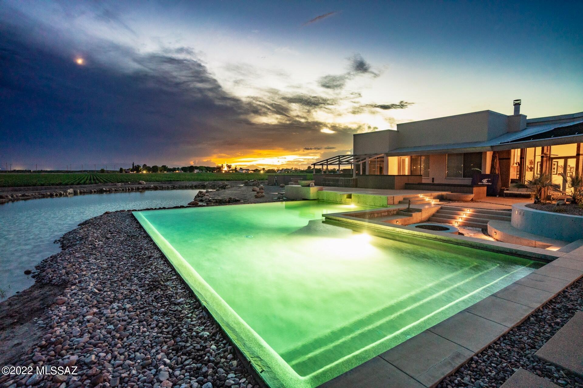 This uniquely built custom home sits approx. on 8 acres including a fenced pasture with corrals. High vaulted ceilings & large glass windows in each room gives picturesque views of beautiful Mt. Graham. On a clear day capture the reflection of the mountains on top the water of the Valley's largest, L-shaped Infinity pool. The heart of the home centers around the open concept kitchen with its striking granite counters & its invitation to entertain a party. Walk the bamboo wood floors & take in the natural light. Imagine preparing meals in this dream kitchen that is geared for anyone who loves to cook, especially in the wood-fire pizza oven. Sit in the family room & cozy up to the fireplace during the winter then finish your day with a bottle of vino from the large, refrigerated wine cellar