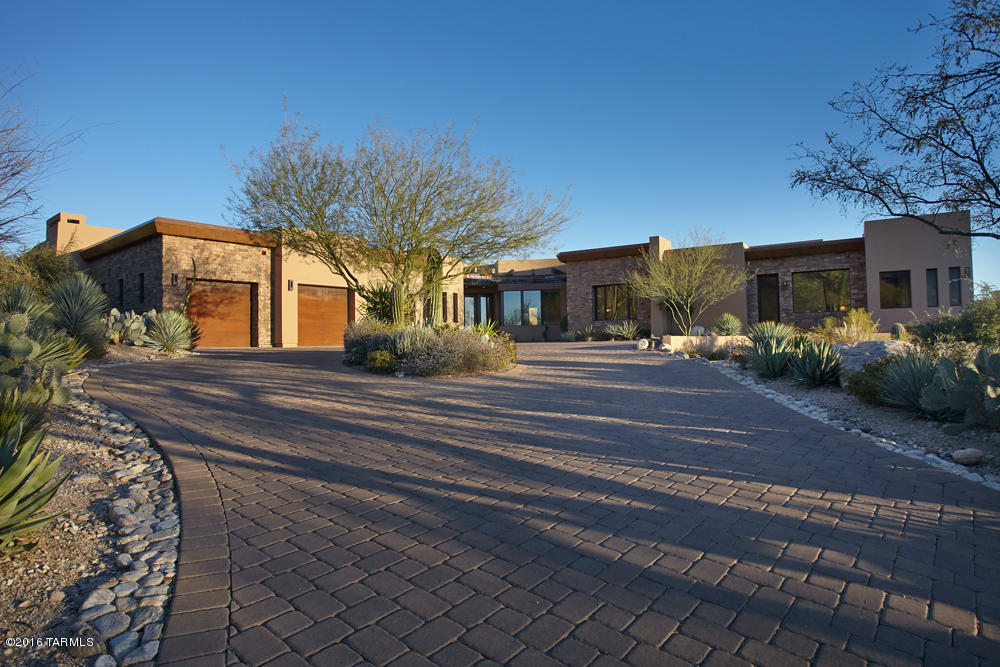 Sophisticated contemporary home on a premium view lot in the 2nd gated area of Pima Canyon Estates.Its many architectural details include curved iron beamed entry,stacked stone, flagstone, Brazilian granite,travertine, tongue & groove & tray ceilings+walls of glass with views from every room.Living rm with wet bar,fireplace, wine rm opens to a covered patio with sunset views on one side and mountain views on the other.The expansive kitchen is richly appointed with top of the line cabinetry,appliances.Sublime master bedroom wing with comfortable sitting area, fireplace, beautifully detailed bath with jetted tub,shower,grand custom closet, laundry rm+exercise rm/office.Gallery hall leads to 4 addt’l bedrooms w/ensuite baths,2nd laundry rm. Stunning yard, pool/spa, sensational mountain view