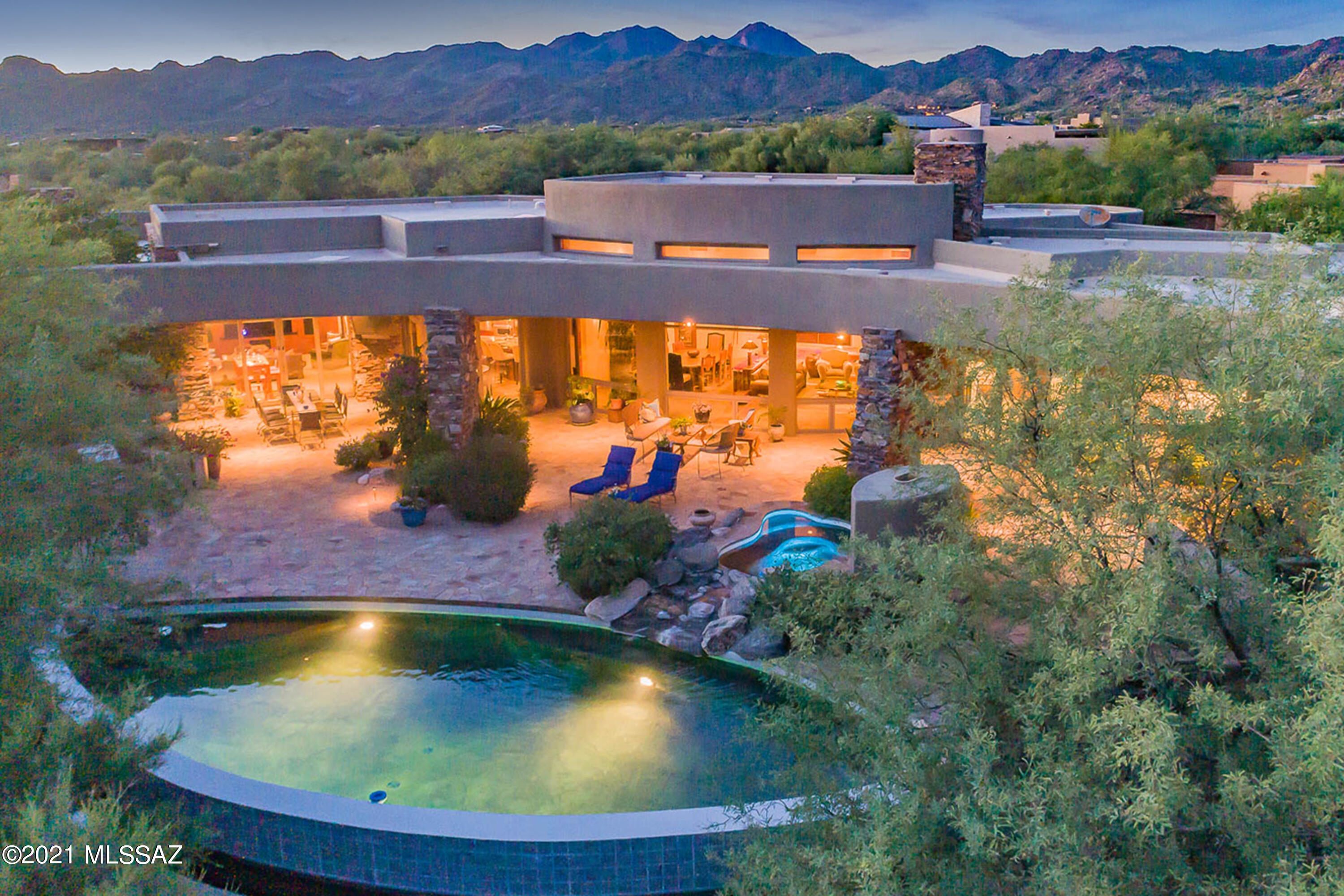 Luxury Living at its Best! Stone Canyon desert Contemporary design by Architect, Ron Robinette and award-winning interior designer, Lori Carroll spared no expense on this exquisitely finished home. Magnificent entry with hand crafted front doors revealing walls of windows and spectacular views of the Santa Catalina mountains. Easy flowing 5,150 sq.ft split floor plan in the main house plus 795 sq.ft. guest house. Total of 4 bedrooms and 6 bathrooms, all en-suite baths, also an executive office suite with fireplace, bath and custom cabinetry. Extremely spacious great room with dramatic custom-made fireplace and mantle. Large sitting area and dining area. 1,000 bottle refrigerated wine room.