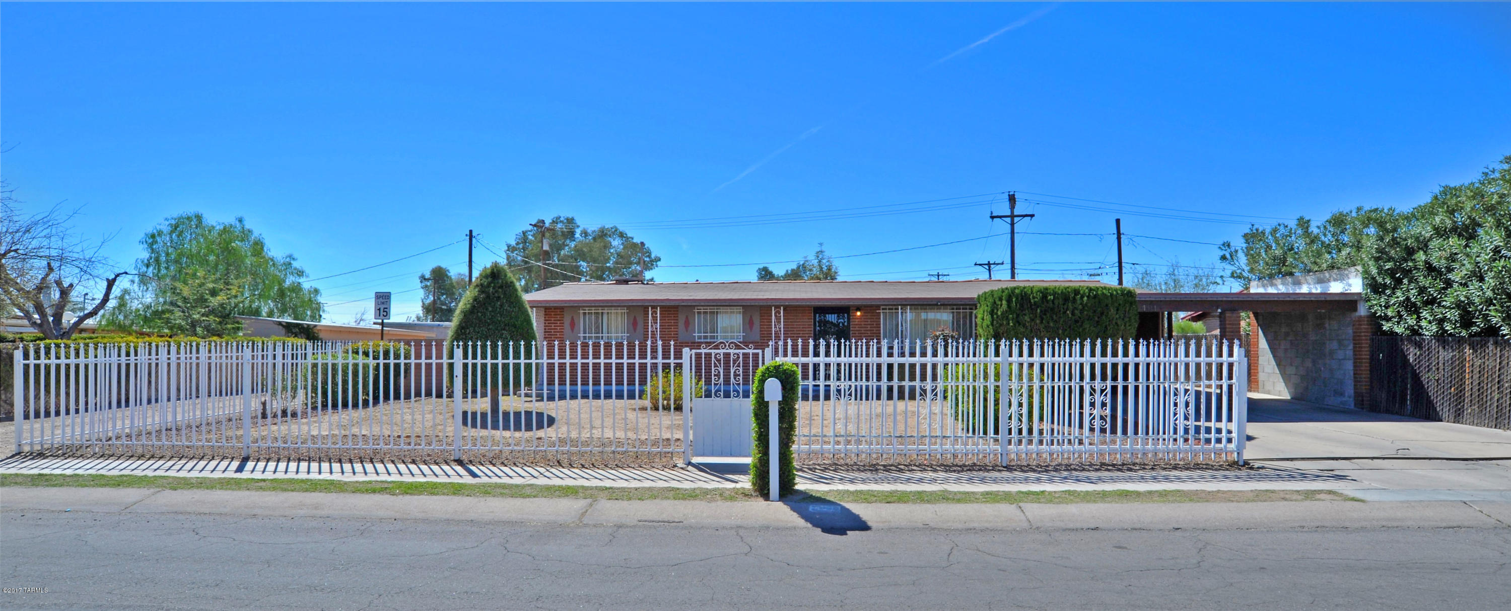 Wonderful move in ready 3/2 home that's been lovingly cared for with great bones.Beautiful front yard landscaping, with mature vegetation. New carpet, kitchen counter tops, large family room, living room, and large Den, perfect for an office or more living space.  Large 2/3 car carport. Ornate wrought iron gate, all brick home. Enough space in back for an RV, pool. Access from backyard, lots of storage.