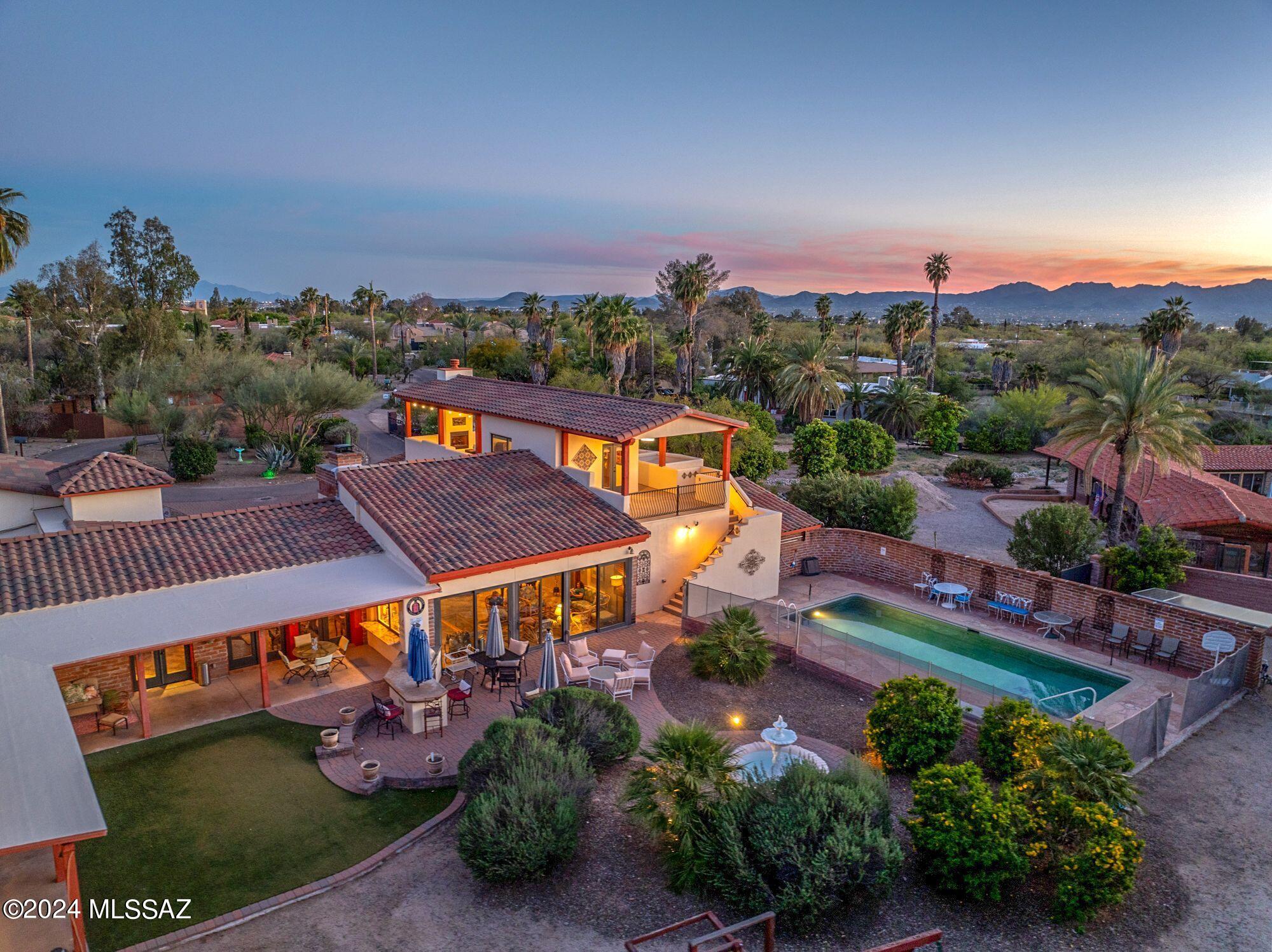 Absolutely stunning Mediterranean Style custom home with an amazing resort-like rear yard. TOTALLY renovated in 2014 down to the studs! Nestled on a private acre lot offering mountain and sunset views. Spacious family and living rooms with high vaulted beam ceilings and cozy fireplace. Gourmet island kitchen w/custom alder cabinetry, granite counters and SS Thermador appliances. Gorgeous 20'' ceramic tile flooring. Beautiful alder doors. Luxurious bathrooms. Covered roof top deck w/fireplace & office. North facing rear yard w/refreshing pool, professional landscaping, BBQ, brick pavers & views! Great north location. See floor plan & custom features list in documents. SEE More section for renovations and info on 1992 Modernization Age. Home built in 1951.  One seller is licensed AZ agent. This amazing one of a kind custom home may have been originally built in the 1950s but the home was remodeled down to the studs in 2014. According to the Pima County Assessor's Office the New effective age due to modernization is 1992 for 2026.
The following was done in 2014.

" All new electric
" All new plumbing
" Walls and ceilings furred out and insulated
" New double paned windows throughout
" Tinted Italian plaster walls in family room, living room, dining room, kitchen, hallway and 1/2
bath.
" All new AC units to include 5 AC zones. 4 HVAC systems downstairs and one split AC unit upstairs
" Solid wood interior alder doors throughout new in 2014
" French doors to deck and patios all new in 2014.
" New tile roof (Built-up portions of roof recoated in 2024.
CUSTOM FEATURES
" Professional landscaping throughout yards and patios
" Situated in Maurice Reid's former orange grove - orange, tangerine and grapefruit trees abound.
" Mature bushes and shade trees throughout yard.
" Low care desert landscaping in front and back patios.
" Custom Iron gates - man and vehicle for ease of access to yard areas.
" Back patio by pool done with Arizona pavers that match front driveway.
" Rainbird zoned irrigation throughout yard/patios.
" Adobe brick with wood frame and stucco (where additions were added in 2014).
" 2 free standing fountains with custom attached bases
" 6 foot block wall surrounds yard for privacy and tranquility
" Citrus based water softener system
" North/South exposure with huge rooftop viewing deck with 360 degree views. Spectacular Catalina
Mountain views.
" Covered patios to North and South with ceiling fans
" Custom Decorative Iron and Glass Front door
" Matching Kodiak granite countertops throughout the house - family room bar, kitchen, laundry and
hallway.
" Lighted Art niches throughout
" Custom blinds throughout
" Uniform 20" ceramic floor tile set on the diagonal throughout the home.
" Top of the line Toto model toilets throughout with so; close lids
" Driveway: Arizona pavers
" Doors to garage and patios all equipped with smart locks.

LIVING ROOM
" Wood Burning fireplace
" Custom carved alder mantle
" Custom iron support column
" Exposed beams
" Ceiling Height: 11'
KITCHEN
" Sonoma Tileworks handmade wall tiles - kitchen backsplash.
" Pot filler
" 2 undermount stainless steel sinks-1 farmhouse, 1 Franke island sink with built in colander &
preparation chopping board
" 2 disposals
" Matching Thermador appliances (double ovens, 5 burner cooktop with griddle, dishwasher,
microwave, fridge and freezer)
" Custom alder cabinets (so; close doors and drawers) and pot/pan pantry pull outs in kitchen.
" Beautiful granite counter tops
" Stained pecan finish and French white finish
" Island has built in desk area
KITCHEN 1/2 BATH
" Sonoma Tileworks handmade wall tiles
DINING AREA
" Room for a table to seat 14
" Chandelier
" Exposed beams
FAMILY ROOM
" Clerestory windows
" Sliding doors to patio and pool
" wired externally mounted speakers in ceiling
" Venetian plaster walls
" Sink, disposal, dishwasher, double tap kegerator, wine fridge and Kodiak granite counters inside and
outside bar area.
" 1/2 bath with marble floor and Sonoma handmade marble tile backsplash
" Custom plantation shutters and sun shades
" Exposed beams
" Ceiling Height: 15'
PRIMARY BATHROOM
" Sonoma Tileworks handmade wall les
" Electric fireplace/heater
" Deep Jetted tub with window and garden views
" Shower tiled wall bench and rain head, telephone and body sprayers in oil rubbed bronze
" His and her separate sinks with vanity and marble counter tops
PRIMARY BEDROOM
" Exposed beams
" French doors to patio and pool area
PRIMARY CLOSET
" Enormous
" Custom alder island and cabinets
" Chandelier
LAUNDRY ROOM
" Custom Alder cabinets
" Kodiak granite countertops
" Stainless Steel undermount sink
" Built up tile pedestal for resting a front load washer/dryer - easy on the back.
" Door to pool area and to Guesthouse for easy houseguest access.
" Washer dryer DO NOT CONVEY
UPPER OFFICE
" 360 degree Mountain Views
POOL
" Huge with built in stairs
" Salt Water
" Replastered in 2014
" Solar Pool Pump
GRILL
" Built in Coyote Grill and stained concrete countertop - close to bar and kegerator
UPPER DECK
" Mountain View's, 360 degree views
" Spectacular sunset views of Catalinas and Tucson Mountains
" Gas fireplace
" Stainless steel bar sink under cover.
" Decorative Spanish tile on covered deck walls and stairs.
" 2 retractable blade ceiling fans/lights.
GARAGE/WORK ROOM
" Work room with utility sink
" 7 car attached garage space. Configured as 6 and 1
GUEST HOUSE
Built in 1952, Needs to be remodeled inside. One room studio with closet and 3/4 bath and new French doors to back covered patio. Guest House is grandfathered but cannot be added on to. 

Septic/leach field redone in 2014
Deed restrictions prohibit building further structures on the property.  
Variance garage corner zero lot line on west side-county permitted.