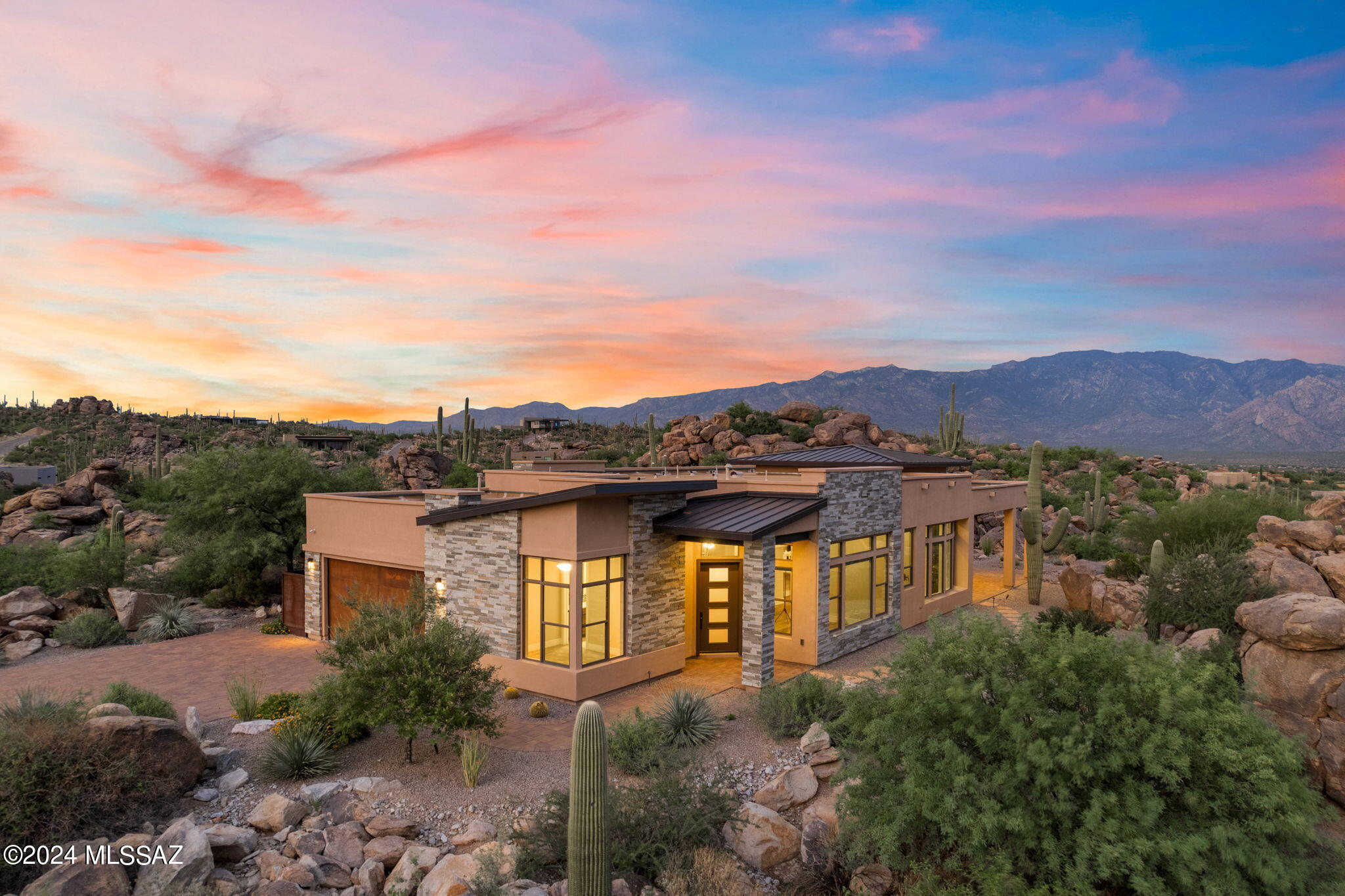 Panoramic and breathtaking views of the majestic Santa Catalina Mountains and the glittering Tucson city lights await you at this private and exquisite elevated homesite in Boulder Vista, located within the prestigious Stone Canyon community.

Set on over an acre, this premium lot offers unparalleled views from every window, unveiling an incredible desert landscape adorned with unique rock formations and hundreds of towering Giant Saguaros. A long paved driveway leads you up to this elevated setting, creating a grand entrance to your serene desert retreat. This is a rare opportunity to live in your dream home, where luxury meets nature, providing an extraordinary backdrop for daily living.
MORE The well-designed split floor plan features ensuite bedrooms and a den, offering both privacy and comfort. With three bathrooms and a convenient powder room, this home is perfectly equipped to cater to your every need, ensuring a lifestyle of ease and sophistication. Built by Meritage, this energy-efficient home will impress you with its numerous upgrades, all meticulously detailed in our features section.

At the heart of the home lies a chef's dream kitchen, boasting a magnificent large Quartzite island with bar seating, two conventional ovens, a microwave/convection oven, and an inviting dining area. This space flows seamlessly into the great room, making it perfect for both everyday living and entertaining.