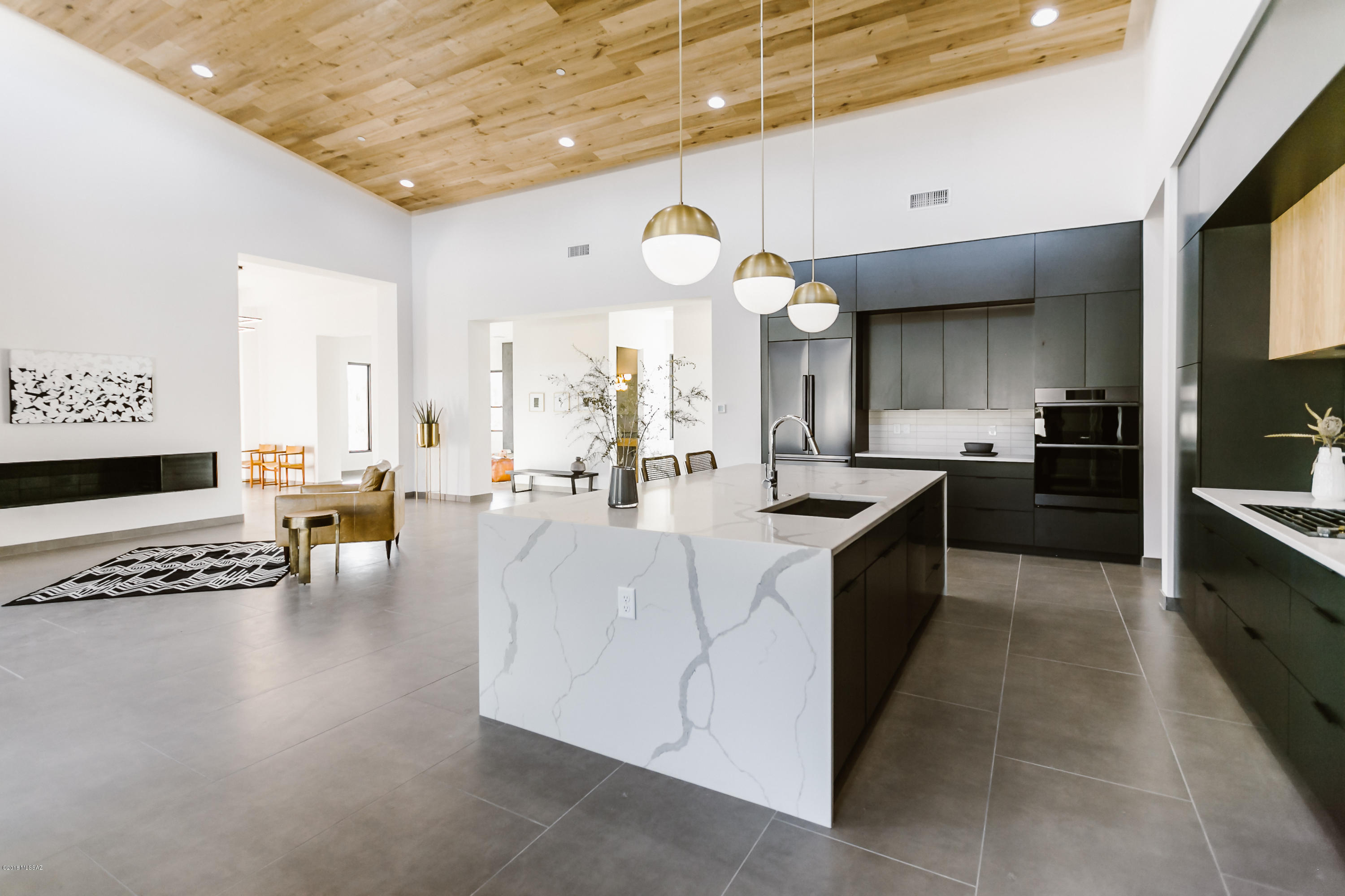 In the heart of Oro Valley, on ''Millionaire's Row'' in Oro Valley Country Club!  Built in 2018.  Mid-century Modern with Scandinavian charm.  Incredible views of Pusch Ridge.  Gorgeous, light, and airy.  Instagram ready!!

Texas limestone entrance, exposed rough-sawn rafters, concrete-look 2x4 tile throughout home -- NO carpet! Backlit 
''floating'' white oak ceiling in great room. Kitchen has large quartz ''waterfall'' island and Dacor Modernist graphite stainless  appliances. 

Huge covered patio and yard. Incredible views.  Room for a pool.  Private access to ''The Loop'' trail system.  Very large 3-car garage.   

Owner/Agent.  Please note pictures were taken upon completion of construction in 2018.  House is currently occupied