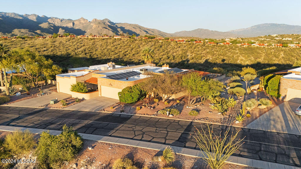 Ridgetop views of the Catalinas & Rincons in the back as well Tucson Mts from the front in this prime, in demand and desired North subdivision of Sunrise Ridge. Large back patio with rock water fall full of mtn. views, charming paver front entrance with water feature, Remodeled main bathroom with Sicilian stone and Taj Mahal quartzite counter tops, New master closet with all the features you would expect by California Closets, updated kitchen with storage and breakfast nook, Solar installed in 2022 with16 panels and net metering with TEP. ,spacious living room with fireplace and Mtn. views, Guest bedroom patio with views of Tucson Mtns.. Plenty of storage in the roomy 2 car garage. This home has everything you could ask for.  It is simply gorgeous.  Walking distance to pool and tennis  ct