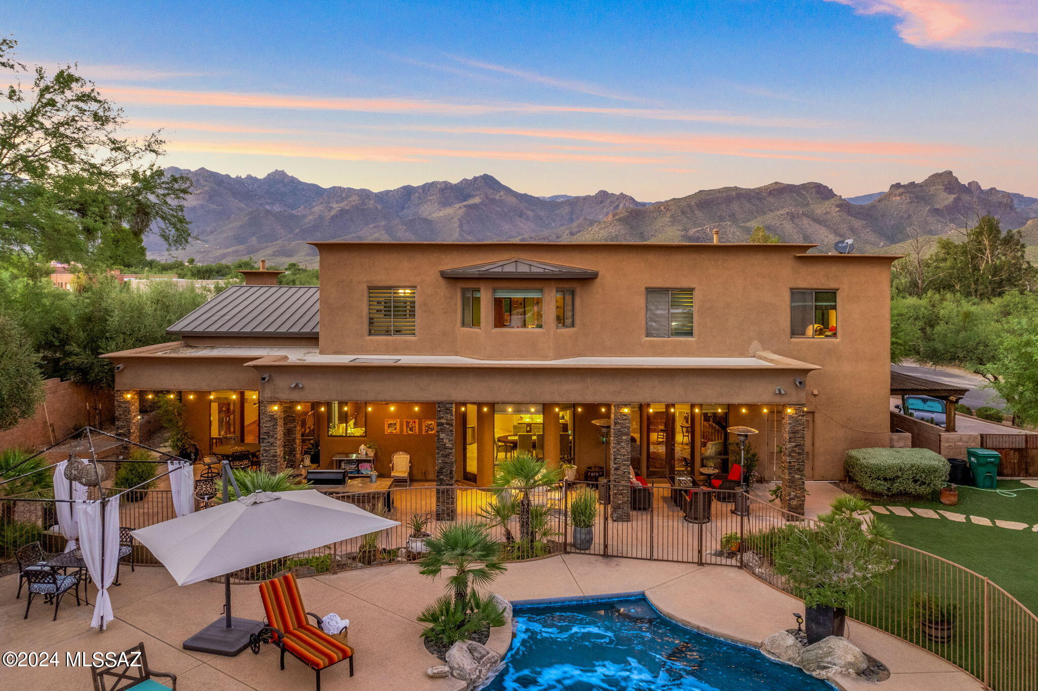TAR HOME TOUR WINNER! This stunning two-story estate in the Sabino Canyon area of the Tucson Foothills offers both luxury and comfort, just a short walk from Canyon Ranch hiking trails. The grand foyer, with terrazzo tile and custom wood staircase under vaulted ceilings, sets a refined tone. Venetian plaster adds elegance throughout, with 5 bedrooms plus a versatile media room that can serve as a 6th. The gourmet kitchen boasts high-end Thermador appliances. A home elevator, perfect for multi-generational living, and the RV/basketball court are added perks. Enjoy Catalina Mountain views by the pool with swim jets for workouts.