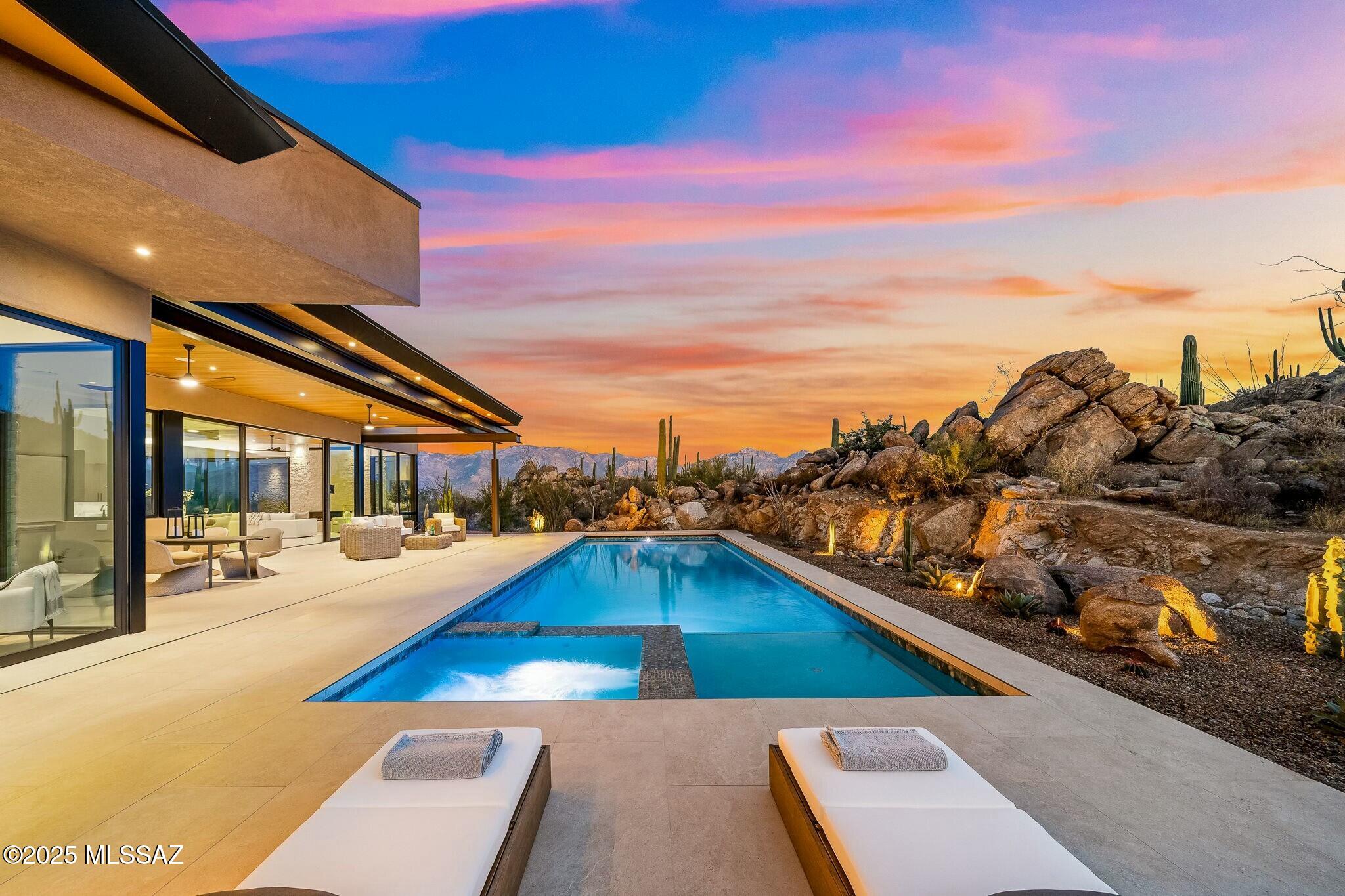 Welcome to an extraordinary opportunity to own a brand-new custom home in the heart of Oro Valley's most prestigious luxury community—Stone Canyon Club. This gated community, celebrated not only for its elegant lifestyle but also for its acclaimed 2025 Golfweek's top residential course ranking (68th in the nation) and recognition by Travel + Leisure as the safest and wealthiest retirement destinations, sets the stage for an unmatched living experience.

Set on a sprawling 1.65-acre lot, this brand-new custom home by Soloway Designs masterfully blends indoor sophistication with the captivating beauty of the Arizona desert. With 3 bedrooms, 3.5 baths, and 3,792 square feet of exquisitely appointed living space, every detail has been thoughtfully curated to elevate your lifestyle. At the heart of the home, the gourmet kitchen is outfitted with top-of-the-line Wolf appliances including a Sub-Zero refrigerator, custom cabinetry, and a generous island crowned with quartzite countertops, this space is as functional as it is beautiful. An adjacent butler's pantry, complete with custom cabinets, shelving, a wine fridge, provides ample storage and a refined backdrop for entertaining.

Expansive 10-foot sliders open effortlessly to a magnificent outdoor patio, where a lap pool/spa and a secluded sanctuary create an idyllic setting to savor the breathtaking views of rugged rock formations, dramatic boulders, and iconic giant saguaros. Whether hosting an intimate gathering or enjoying a quiet moment, the outdoor living spaces are designed to impress.

The luxurious master retreat offers a private haven with unparalleled views. A slider opens directly to the outdoors, linking the serene interior to a spa-like setting complete with a decorative stone wall. The master bath is a sanctuary in itself featuring a steam shower, radiant heated flooring, quartzite countertops, a double vanity, and a relaxing soaking tub. A custom-designed master closet, adorned with abundant shelving and a quartzite island, ensures a seamless blend of style and functionality. An adjacent flex room provides versatile space perfect for an exercise room, home office, or cozy den, complemented by a screened-in patio that beckons you to enjoy the fresh desert air.

Two beautifully appointed guest bedrooms, each with its own ensuite, capture captivating mountain views and offer generous proportions. The spacious laundry room, outfitted with additional cabinetry, quartzite countertops, and a full-size fridge and freezer, further underscores the home's meticulous attention to detail. A three-car garage with extra storage completes this extraordinary offering.

As a resident of Stone Canyon Club, you will enjoy a wealth of amenities, including an elegant clubhouse with a fine dining restaurant, a state-of-the-art fitness center with a lap pool, tennis, pickleball, and a vibrant calendar of social events that foster a close-knit community spirit. Located mere minutes from hiking and biking trails, exquisite restaurants, premier shopping, and world-class healthcare, this property encapsulates the very essence of luxurious, convenient living.

Do not miss this rare opportunity to own a brand-new, custom-designed home without the hassle of a lengthy build process. Schedule your private tour today and experience firsthand the unparalleled beauty and sophistication that awaits at Stone Canyon Club in Oro Valley.