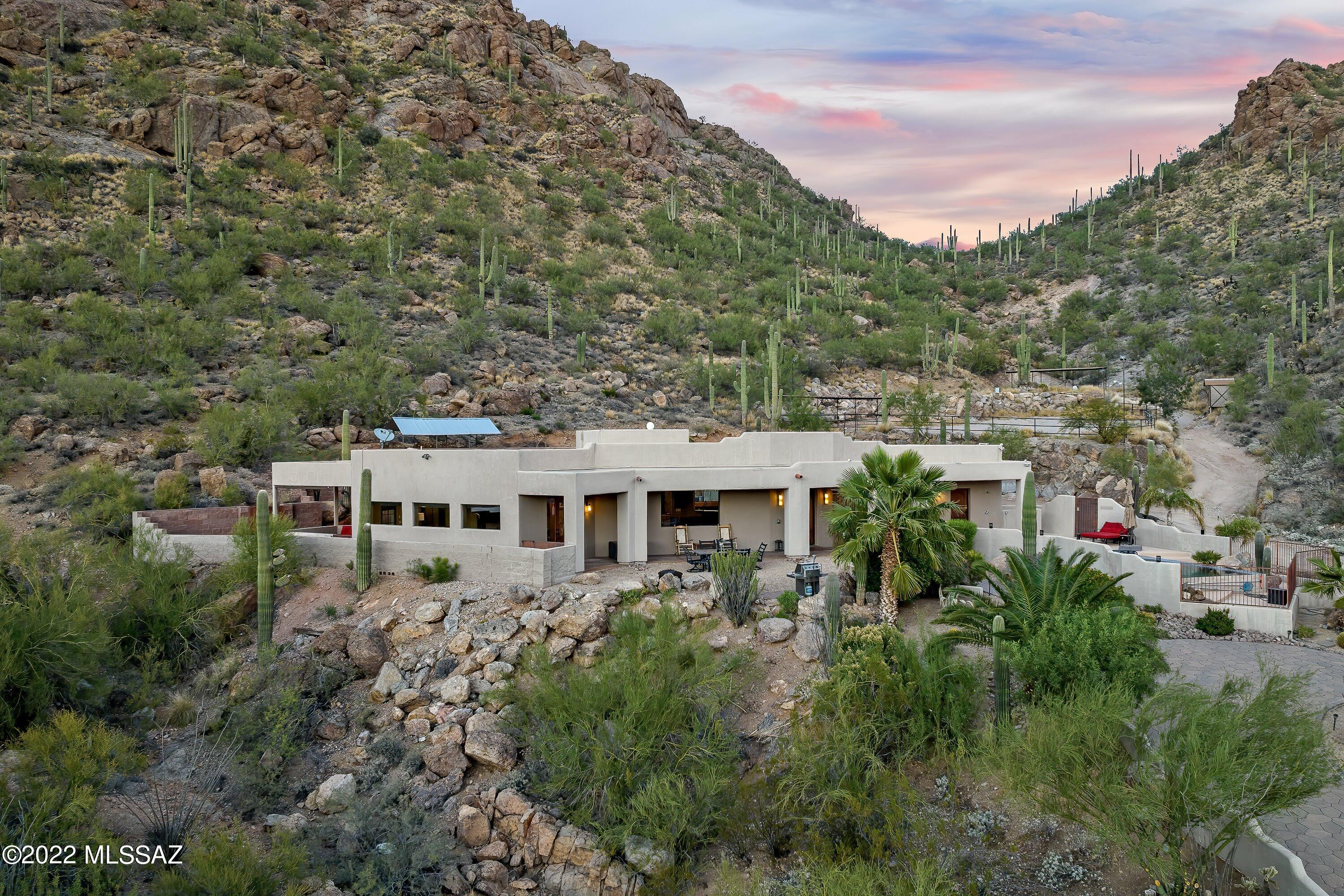Presenting a magnificent mountain-enclave estate with million-dollar views on 11.32 acres of private luxury desert surroundings. This gorgeous 3532 square foot custom-built home offers 3 bedrooms with a large Owner's Suite, 2.5 bathrooms, a separate den or office and a sparkling Pebble Tec pool with an outdoor shower.  Inside, a chef's delight complete with a gourmet kitchen, high-end stainless appliances, wine fridge, granite countertops, custom cabinetry, and a walk-in pantry. An extended 3-car garage with lots of additional storage and with no HOA, bring your toys and trailers. The equine facilities include a horse shed and corral with compacted Earth, lighted outdoor-arena, tractor shed, feed shed, and a ramada with water and electric. Expand your outdoor living to allow nature in with multiple outdoor covered patios and hiking at your doorstep. Location with convenience to freeways, shopping, restaurants, the airport, downtown and yet tucked away on your own mountainside. The property is completely private and no further subdividing, but plenty of room for a guest house. You must see this truly remarkable and one-of-a-kind property to experience the Sonoran Deserts finest.