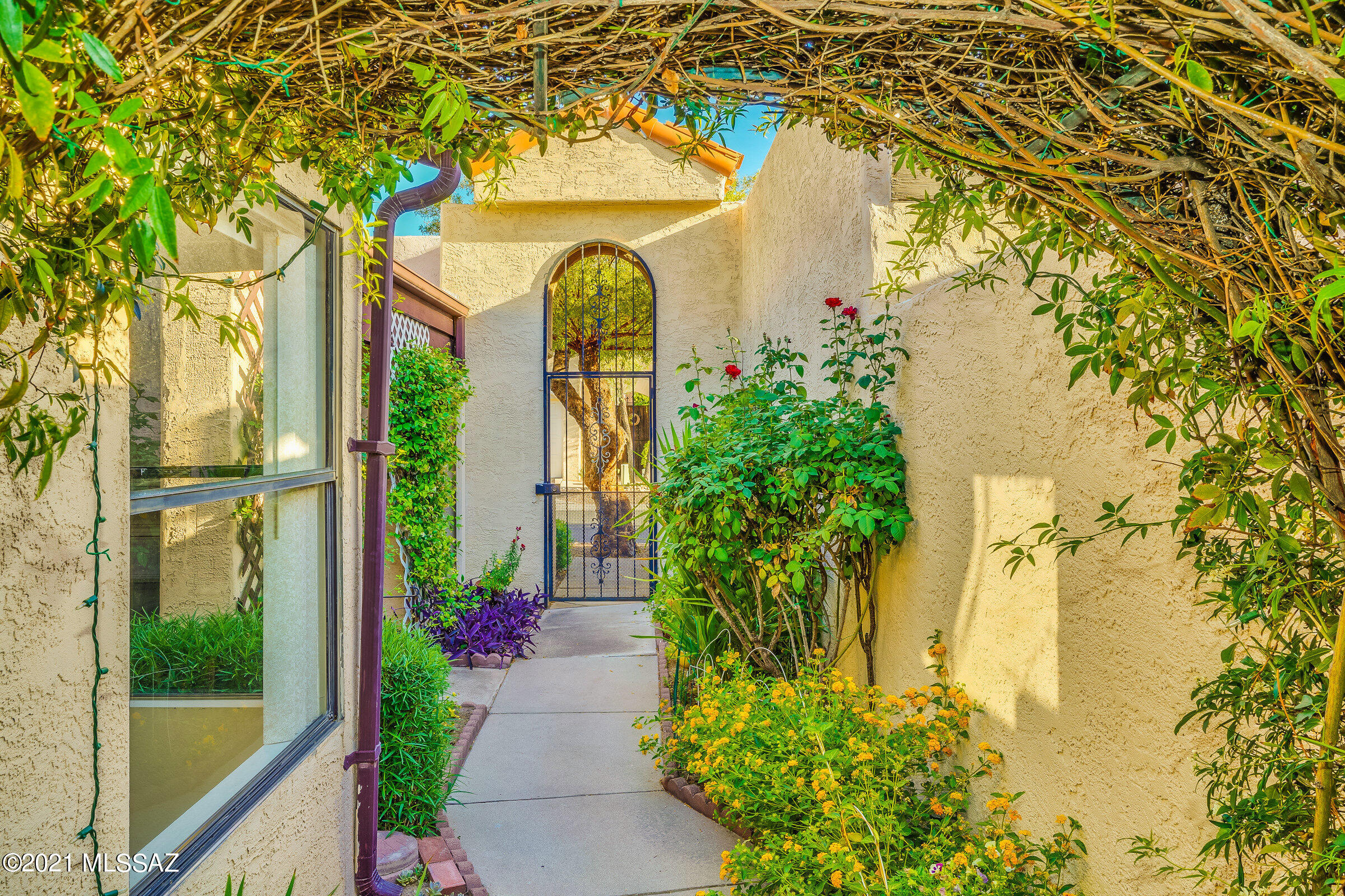 East side, light and bright townhome features 2 bedrooms, 2 bathrooms, high ceilings, beautiful tile flooring and a gorgeous patio yard space!  Mature vegetation of blooming varieties, working koi pond and fountain, it's truly a garden oasis.  Mountain views from the covered patio and great room windows. All appliances convey. Great investment opportunity (complex allows rentals) or owner occupied dream home. Hurry!