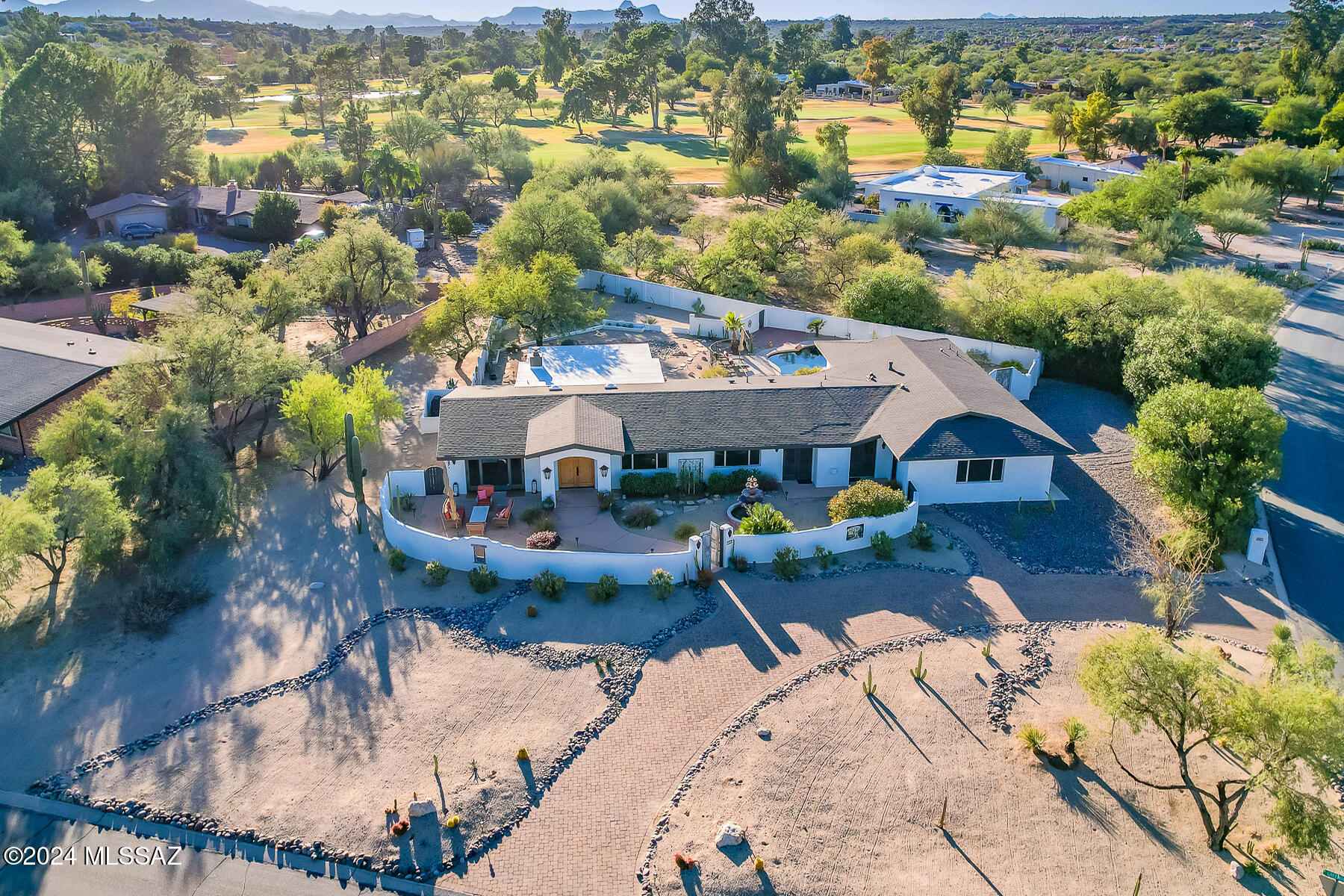 Gorgeous 4BD/3BA (3,009 sq ft) custom Southwest Contemporary with private guest casita plus gated pool & spa is situated within Oro Valley Country Club Estates. Residing on a .68 acre corner lot with circular brick drive, stunning views of Pusch Ridge can be admired from the large, gated front courtyard with flagstone patio and tiered fountain. Architectural detail abounds with vaulted & coffered ceilings, light filtering skylights, and dramatic wood slat archway defining formal & informal living spaces. Luxurious 20'' diagonal set Travertine in most rooms with two carpeted bedrooms and bonus room off garage. Living room with courtyard view flows to an impressive Great room with walls of windows, Kiva fireplace, open dining area and surround sound. Striking chef's kitchen boasts a brick walled backsplash, outer island with bar seating plus granite countertops, stainless appliances including in-wall ovens and 6-burner gas cooktop, farmhouse sink, custom cabinetry and large pantry. Owner's suite is a dream with dual French doors off courtyard, cozy fireplace and luxury bath with dual vanities, jetted tub with Travertine surround and glass block window, plus floor-to-ceiling Travertine tiled walk-in shower. Adjacent walk-in clothes closet accesses laundry closet off garage. Two additional bedrooms with views access a luxury hall bath. Large bonus room off garage & courtyard offers Pusch Ridge views. Relax on the covered rear patio with brick pavers that extends to a casita with private entrance, en suite bath and pool access. Large, tranquil yard offers mature shade trees and desert plantings while entire property has privacy wall. Additional amenities include alarm system, outdoor security lights, zoned heating & cooling, 3 car garage with attached cabinets and shelving units plus water softener. Oro Valley Country Club boasts scenic tree-lined streets, clubhouse, 18-hole golf, fine dining and fitness center. A true desert oasis within close proximity to shopping, dining, the Hilton El Conquistador Resort and Catalina State Park. Perfect for the most discerning buyer!