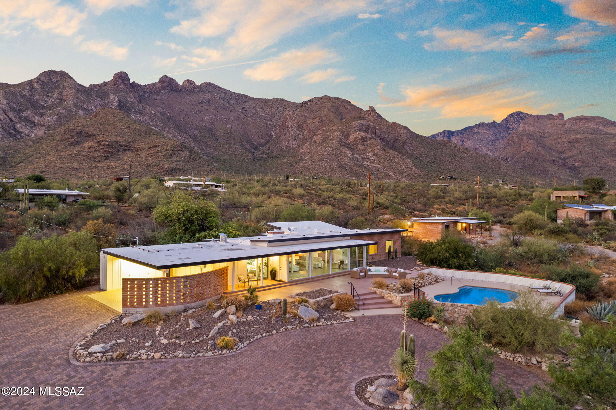 Welcome to luxury living in the picturesque Catalina Foothills! This stunning mid-century modern property offers a rare opportunity to own 4 acres overlooking the surrounding mountains & cityscape. The main house features 4 BR, 3 BA + Studio, pool, & separate guest house with a private driveway just steps away. Meticulously maintained with numerous upgrades, including the gated paver driveway, custom kitchen & cabinetry, renovated bathrooms, upgraded windows & doors, backyard lighting & irrigation, new appliances & more! The property offers privacy & serene desert landscaping, while being within minutes of the Iris Dewhirst Pima Canyon Trail System, restaurants, & shopping. Enjoy nods to the original character of the home as well, originally designed by Tucson Architect, Bernard Friedman.