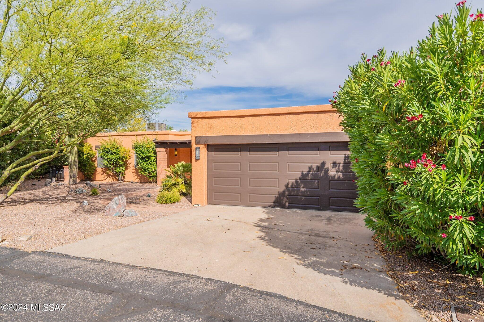 This Continental Vistas home offers a park like setting in central Green Valley just moments from shopping, restaurants, and more. The home is set back in a cul de sac providing privacy and a large lot to enjoy the surrounding nature. Enter through a covered from porch into a formal dining area just off your open concept kitchen. The kiva fireplace is the focal point of the main living space and a breakfast nook connects the living room and kitchen area. You will find stainless steel appliances and attractive knotty pine cabinetry in the kitchen along with a coffee nook and breakfast bar overlooking the dining area. You will appreciate the laminate wood flooring throughout the home. Down the hall you will find two guest bedrooms connected by French doors. These can be used as two traditional bedrooms or a convenient den or office space. The primary bedroom features a walk in closet, en suite, and direct access to the covered patio. The outdoor space is truly and must see! The wrap around covered patio offers plenty of room for seating to enjoy the serene natural setting. The center piece of the backyard is the raised deck perfect for sunset viewing. The backyard continues through a custom wrought iron gate leading to another gathering space complete with a pergola and surrounded by mature landscaping. Don't miss this special Green Valley home.