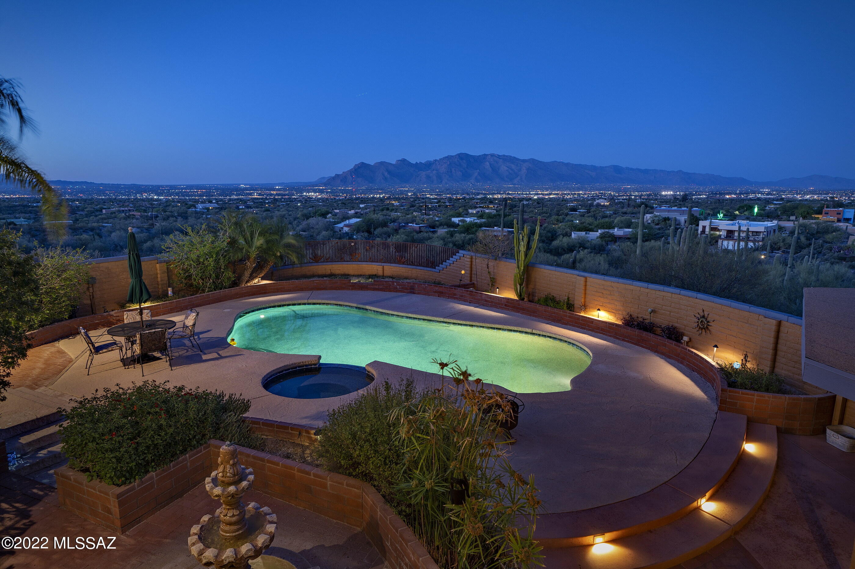 Spectacular cactus studded estate situated on elevated 5 acre lot with glorious panoramic views.  Sit on the full length covered patio & watch the light dance across the mountains, the moon rise, & the city lights twinkle.  The resort-style backyard features a pool, spa, & ramada. Newer kitchen appliances, granite counter tops, breakfast bar, open to family room w/wood burning beehive fireplace.  BOTH full baths were remodeled w/bathtub in 2nd full bath .  Ceramic tile throughout. Separate large utility room/ half bath has separate entrance from covered patio, convenient for those using the pool.  Walk out lower level can serve as guest quarters, rental, studio, office.  Very special property for those that want exceptional views on a larger piece of land. Exterior of home recently painted. Pool table can convey with the home.  Close to downtown and the University.  Truly a magical place. Floor plan and disclosures are attached to the listing.