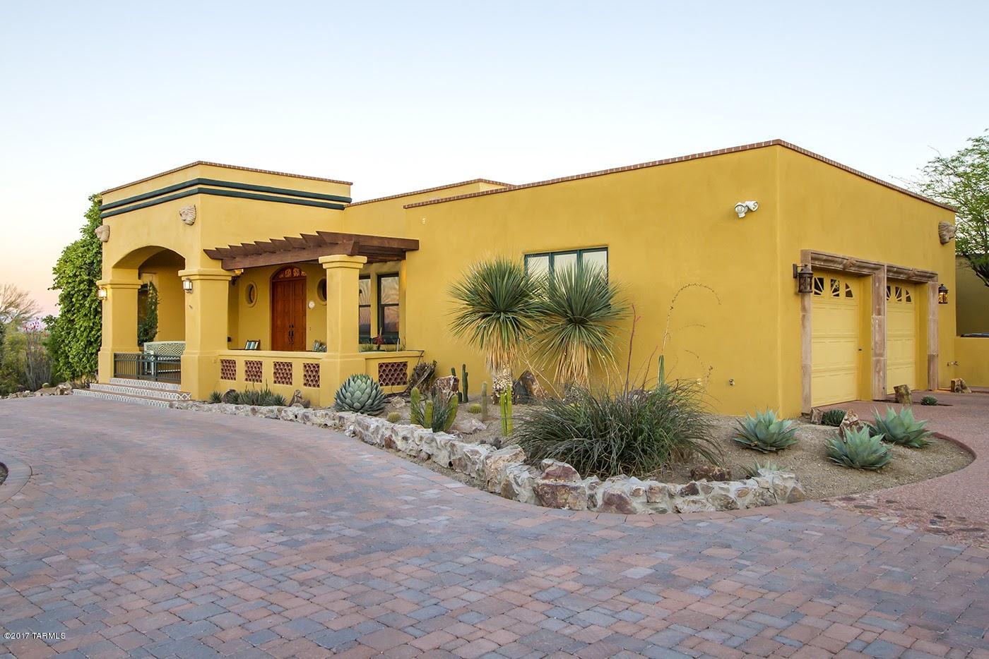Exceptional Spanish inspired home designed by Arturo Coppola and perched high on a hill top with panoramic city views.  Built in 1997, yet oozing with Old World charm and unique architectural details.  Features include colored concrete floors, wood beamed ceilings, wood windows and doors that make you feel a part of the outdoors.  The spacious eat in kitchen is perfect for entertaining.  Romantic master suite includes fireplace, spa like bathroom, custom walk in closet and exercise room.  Enjoy the tranquil ambiance of the office/study.  This home wraps around a luscious and private backyard with an impressive fountain, new outdoor BBQ and dramatic pebble tech pool with a ramada.  Located in a gated community nestled in the Tucson mountains.  Feels away from it all, but so close to town.
