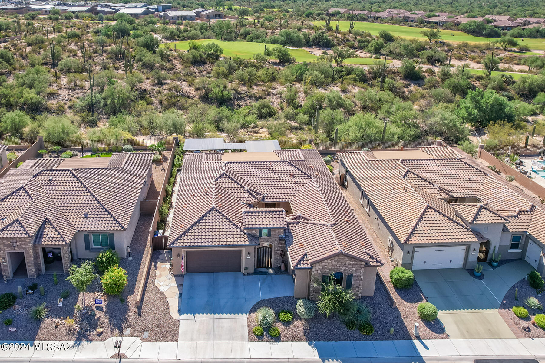 Luxurious 2BD/2.5BA +Den (2,514 sq ft) home boasts a gated front courtyard with fountain, guest wing off courtyard with den/office, plus spectacular rear oasis backing to large common area off golf course for privacy. Stacked stone facade with decorative entry gate flows to open concept gathering room with media wall, surround speakers and retractable glass sliding doors to enjoy indoor/outdoor living. Gourmet kitchen with butler's pantry showcases curved center island, breakfast nook, granite countertops with decorative tiled backsplash, plus stainless appliances including 5-burner gas cooktop. Walk-in pantry and laundry are enclosed by sliding barn doors. Second den or formal dining room lies off foyer. Elegant Owner's suite accesses rear patio with hot tub and hosts a sleek bath with dual vanities, granite countertops and elongated walk-in rain shower. Guest bedroom offers a Murphy bed and en suite bath with tiled shower and walk-in closet. Relax or entertain in the phenomenal rear yard boasting covered patio with stacked stone fireplace, raised patio with elongated BBQ station, beverage fridge and bar seating, linear waterfall feature, outer dining area, metal shade pergolas with louvers, plus raised hot tub patio, decorative turf, outdoor speakers and peeks of several mountain ranges. Additional amenities include gorgeous vinyl plank flooring, ceramic tiled baths and carpeted guest den, plus powder room, tray ceilings, tankless water heater, water purification system and split garage bays (2+1). This 55+ active adult community in desirable Del Webb at Dove Mountain lies just beyond the Ritz-Carlton Resort and within a short distance of hiking & biking trails. Perfect for the most discerning buyer!