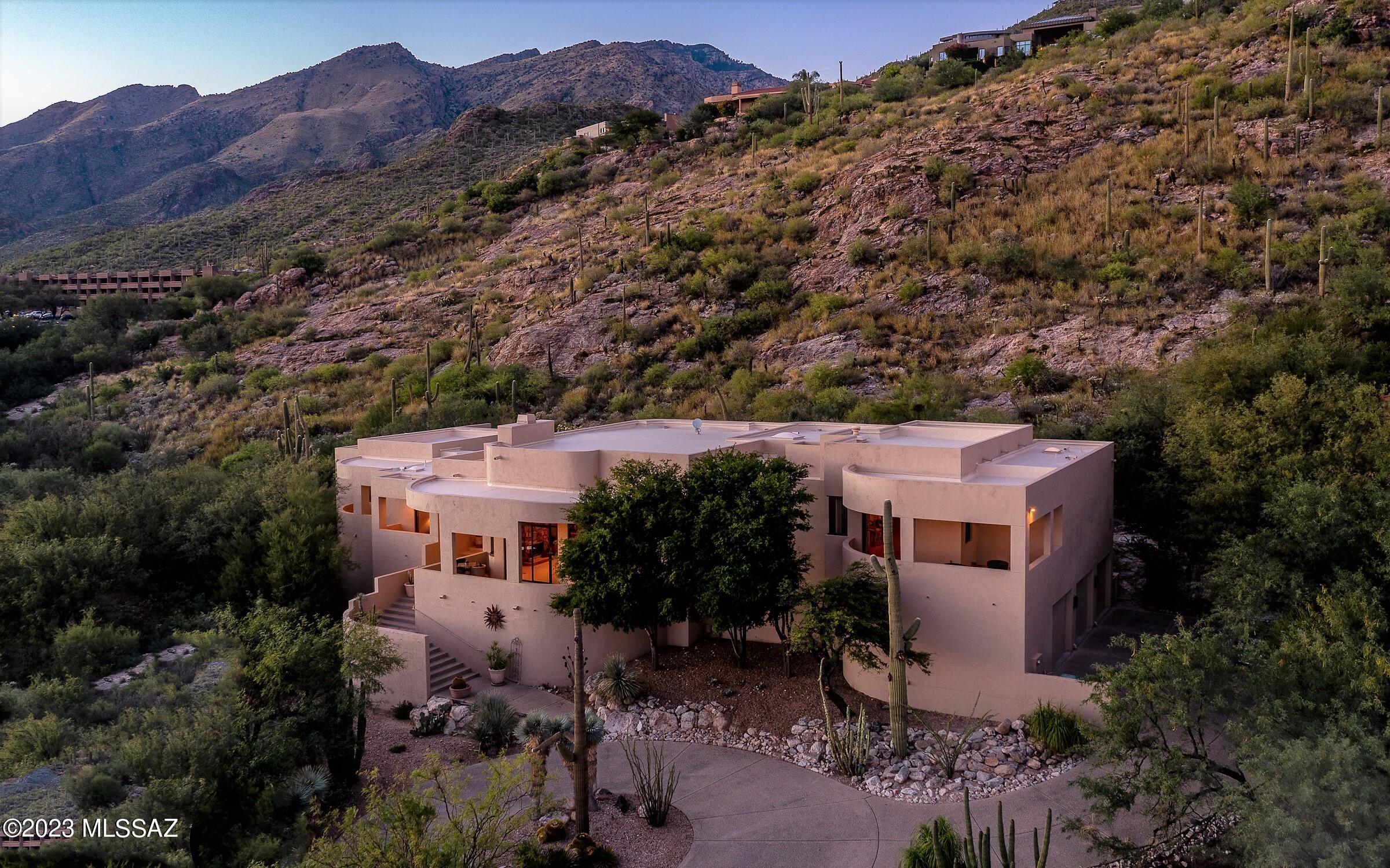 Panoramic views surround this beautiful Southwestern Contemporary located in the highly sought after community of Ventana Canyon. Your secluded backyard showcases a sparkling pool, spa, waterfall, full bath and is nestled against the Catalina Mountains surrounded by lush desert landscape. Four south facing balconies capture the twinkling city lights. Custom finishes include flagstone flooring plus Alder cabinets & doors throughout. Entertain in the family room w/easy access to the wet bar & home theater. The refined kitchen is well equipped w/Subzero, Dacor & Viking appliances & a casual dining space. Formal living & dining rooms are spacious & share a magnificent view. Two primary suites have generous baths & large walk-in closets. Oversized 3 car garage has dumb waiter & storage.