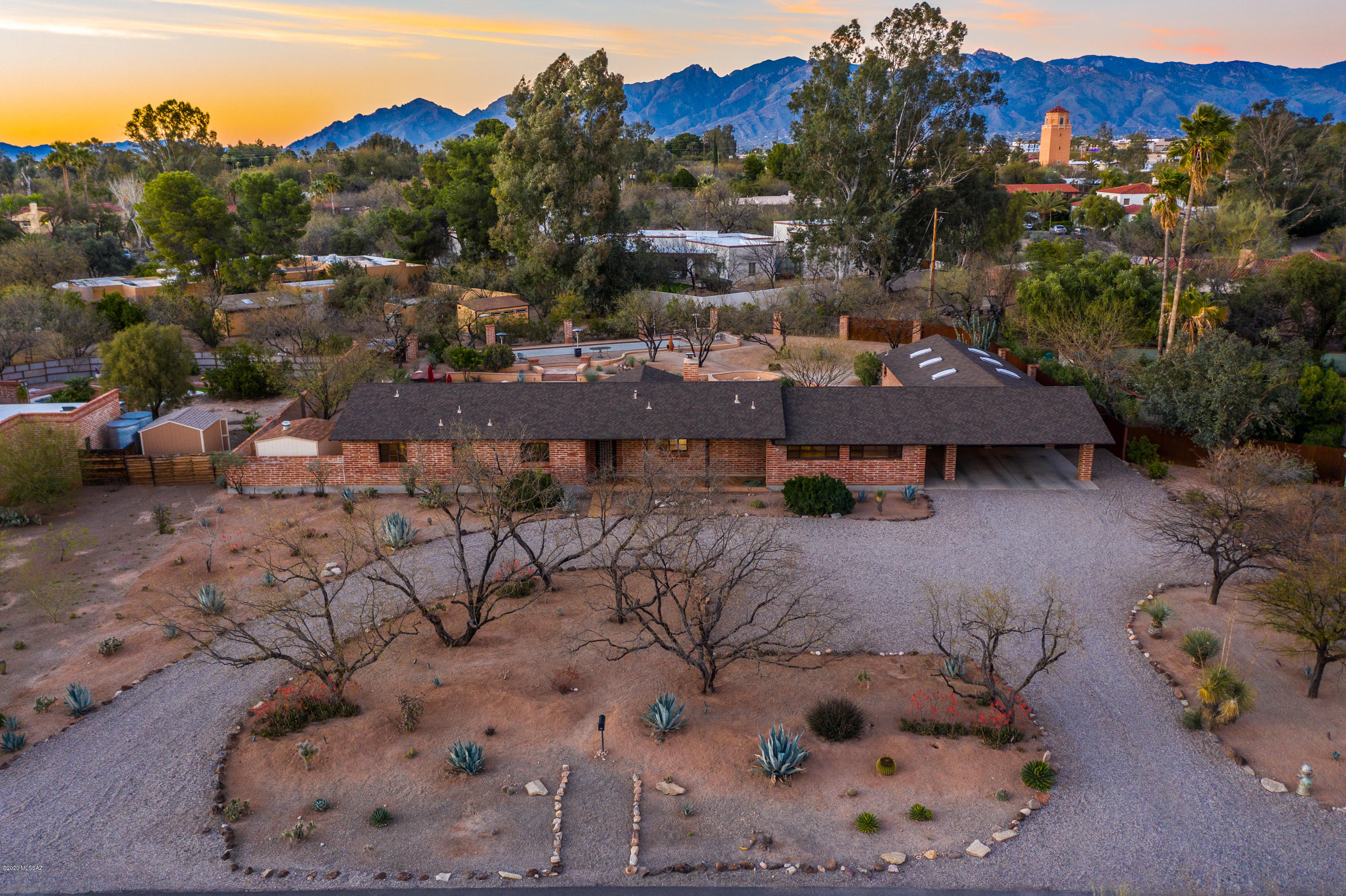 This is a truly amazing property, in desirable location close to everything in Colonia Solana. This historic burnt adobe home is open & bright w/wonderful living spaces & large windows to bring all the beauty of the property inside! Large 3/4 acre lot with huge fenced in yard made for entertaining, w/multiple places to gather. Great pool, w/new equipment, hot tub spa, fire pit & a full bocce court, all surrounded by beautiful flagstone & wonderful lighting to enjoy the space day & night. A true car lovers dream 4 car garage, w/high ceilings & steel hoist beam. Garage also has 6 skylights, evap cooler, steel workbench & shelves, & 220 amp electrical. Plus its own separate 1/2 bathroom. You may never need to go inside, even though you'll want to enjoy everything about this amazing home!