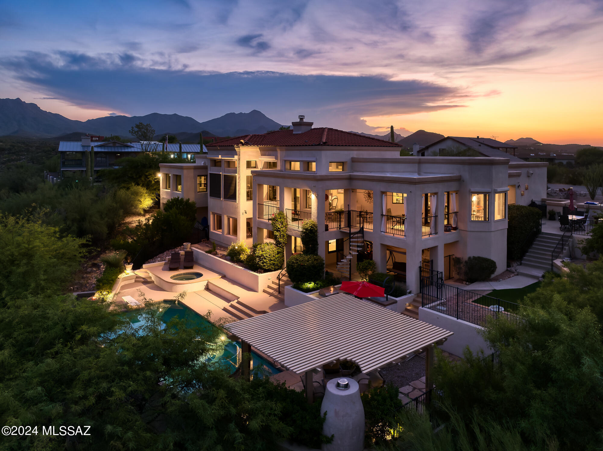 Sophistication and nature unite. Tucked away at the southern end of Rancho Del Cerro, 5135 W Paseo Del Campo sits on an elevated lot showcasing the glorious desert, mountains, sunsets and city lights. Offering a private access point to the world class biking, hiking, riding & running trails at Sweetwater Preserve (1/4 mile away), the outdoor lifestyle from this location is dynamic. While the setting feels rural and casual, Downtown Tucson is only 16 minutes away. Spanning 4349 square feet over two levels, the layout and use possibilities are many. Situated to capture the magnificent views, large picture windows create a visual pathway outdoors from all spaces. The main (upper) level includes 2 living & dining spaces, the primary suite, 2 guest rooms with a jack & jill bath, laundry & powder room. Travertine floors, high ceilings and built in bookshelves all nod to the custom design of this home.

The lower level, which has access via a staircase or a wheelchair lift, includes a separate living space, bedroom and full bath. Multi-generational living would be easily accommodated here, as would a work from home setup.

The outdoor experience is layered and private. A sizable terrace from the main level is perfectly positioned to take in sunrise, sunset or city lights. The eastern side yard includes additional seating space, an area with synthetic grass, and citrus. Cocooned by a layer of green with peeks of the Catalina Mountains, the expansive pool area feels resort-like. Expanding beyond the backyard, the lot provides separation from neighboring homes, both physically and in terms of elevation. With Southern exposure, the orientation takes advantage of passive solar. Space to park an RV or travel trailer is available.