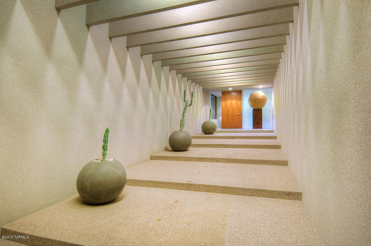 Outstanding and exceptional minimalist contemporary home by renowned builder/architect Rick Joy in prestigious and gated Pima Canyon Estates. Located on a private cul-de-sac with mountain and city views, this all masonry home featured on the cover of Tucson Lifestyle Magazine features 3 bedrooms (including casita) plus den and studio, natural concrete floors, Ameristone interior and exterior finishes, brushed stainless steel, Optic White Corian counter tops, walnut built-in cabinets and front door, frosted glass, Dorn Brach brushed nickel hardware and 11' ceilings throughout. Enter through unique steel revolving door opening to elegant gallery entry into great room with walls of windows, gourmet kitchen with Sub-Zero and Viking appliances, outdoor center courtyard with kitchen,