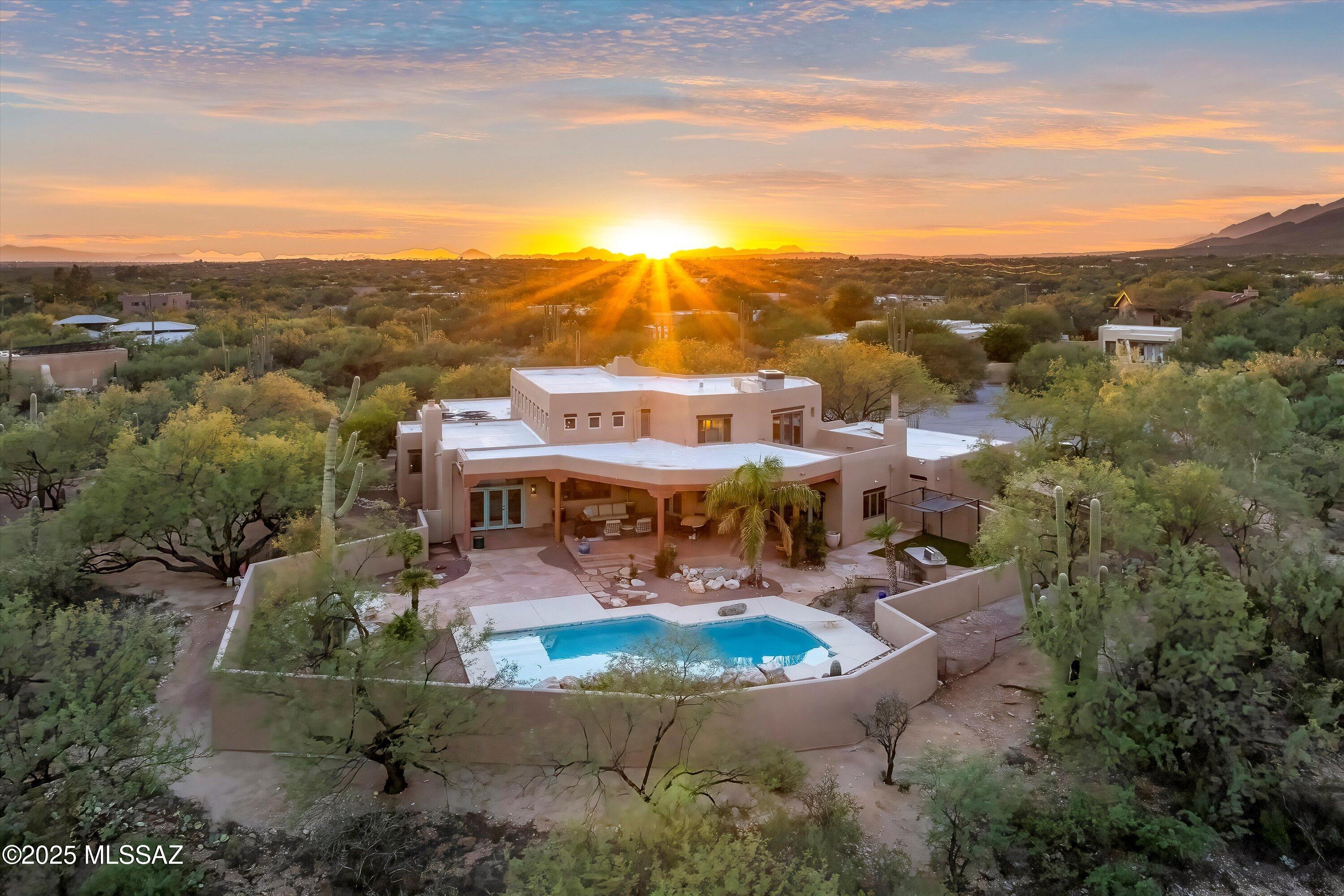 Once-in-a-lifetime opportunity to own private, stunning 10-acre property with 4 bedroom, 3 bath home featuring panoramic mountain views. The home features beautiful living spaces, inside and out. There's a landscaped courtyard, pool + bbq, walking trails, mature desert landscape, all overlooking lush wash. A tranquil stone fountain greets you upon entry with soaring ceilings with wood beams, separate living and family rooms, both with fireplaces, are open yet cozy. Primary suite upstairs features wood floors, large walk-in closet, gorgeous custom bath featuring separate shower + soaker tub. 3 additional bedrooms downstairs with beautifully updated hall bath. Kitchen features custom stone counters w/ bar-height island and tons of storage. Rustic feel but on City Water + paved road.
