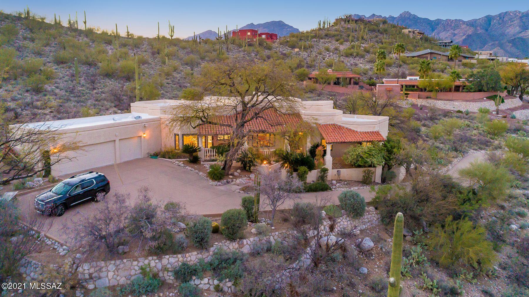 Welcome to a warm, welcoming and gracious Mediterranean-style home, artfully nestled into a tranquil cul-de-sac on a hill in the Sabino Vista Hills area of Tucson, immediately behind famed Canyon Ranch. Enjoy daily walks along the two- mile Canyon Ranch Trail where you will meet your neighbors and also visitors to the Ranch from around the world. Wrap-around views of both the Rincon and Catalina Mountains, plus city lights in the evening,  from every window, terrace and patio enhance the beauty of an already lovely home. The elegant entry is graced by mature manicured landscaping including a magnificent  ancient mesquite and fabulous huge specimens of Sego Palms. Handsome arched wooden entry doors lead to a foyer and the large open great room, with a gas-lit fireplace and space for multiple cozy seating areas and even a grand piano! Views, but of course, in all directions. Nearby casement sliding doors lead to the generous and handsomely-landscaped rear yard (this home includes 1 ½ lots) with multiple levels and areas to gather and enjoy the views. There is plenty of room to add a pool and spa, the finishing touch for this very special home. Back inside, the graceful dining room has a handsome iron and smoky glass chandelier, room for a sideboard, and views again, over the charming front terrace, of mountains and city lights. The kitchen area is terrific, with plenty of great space and storage for the chef and top-of-the-line appliances including Jenn-Air double ovens, new Jenn-Air induction cook top (also stubbed for gas), and built-in Sub-Zero refrigerator. The kitchen has a sizable desk area topped with stunning leaded crystal cabinetry to display your collections. Adjacent is the large breakfast area that opens to the terrace, providing plenty of room for friends and family to gather. One wing of the home includes the beautiful master bedroom and another bedroom/office and full bath. The irregularly shaped master bedroom provides space for a sitting area, with more casement sliding doors out to the rear terraces. The master bath is finished with marble and features a truly "garden" tub with views overlooking the rear gardens, along with a walk-in shower, attractive glass shelving, separate commode and large closet with built-in drawers and shelving. That second bedroom is presently utilized as an office with another large walk-in closet, creating a private owners' suite. The other side of the home provides two additional large bedrooms with walk-in closets and mountain views and a third full bath with a large glass-front walk-in shower. Most floors are handsome stone-like ceramic tiles, and all windows are casement style by Pella. Ceilings are tall, between 9' and 19'. Enjoy the tranquil beauty of the desert, sunrises over the mountains, and the awesome late-summer panoramas of the monsoons rumbling over the Catalinas and Rincons. It's a friendly neighborhood, where you meet neighbors on morning and evening walks. It's also multi-generational, with retirees from around the U.S. and families who regularly use the recreational facilities and pool for after-school swim meets and take part in holiday festivities coordinated by a group of neighbors committed to making the community a friendly place for all to live. The Sabino Canyon Recreational Area is minutes away and offers endless hiking for outdoor enthusiasts. There are a myriad of top-notch restaurants in the area. The Canyon Ranch boutiques are accessible to locals and have fabulous goodies. Y'all come on over to see this beauty! Seller has installed two new water heaters on 4-16-21 with warranty.