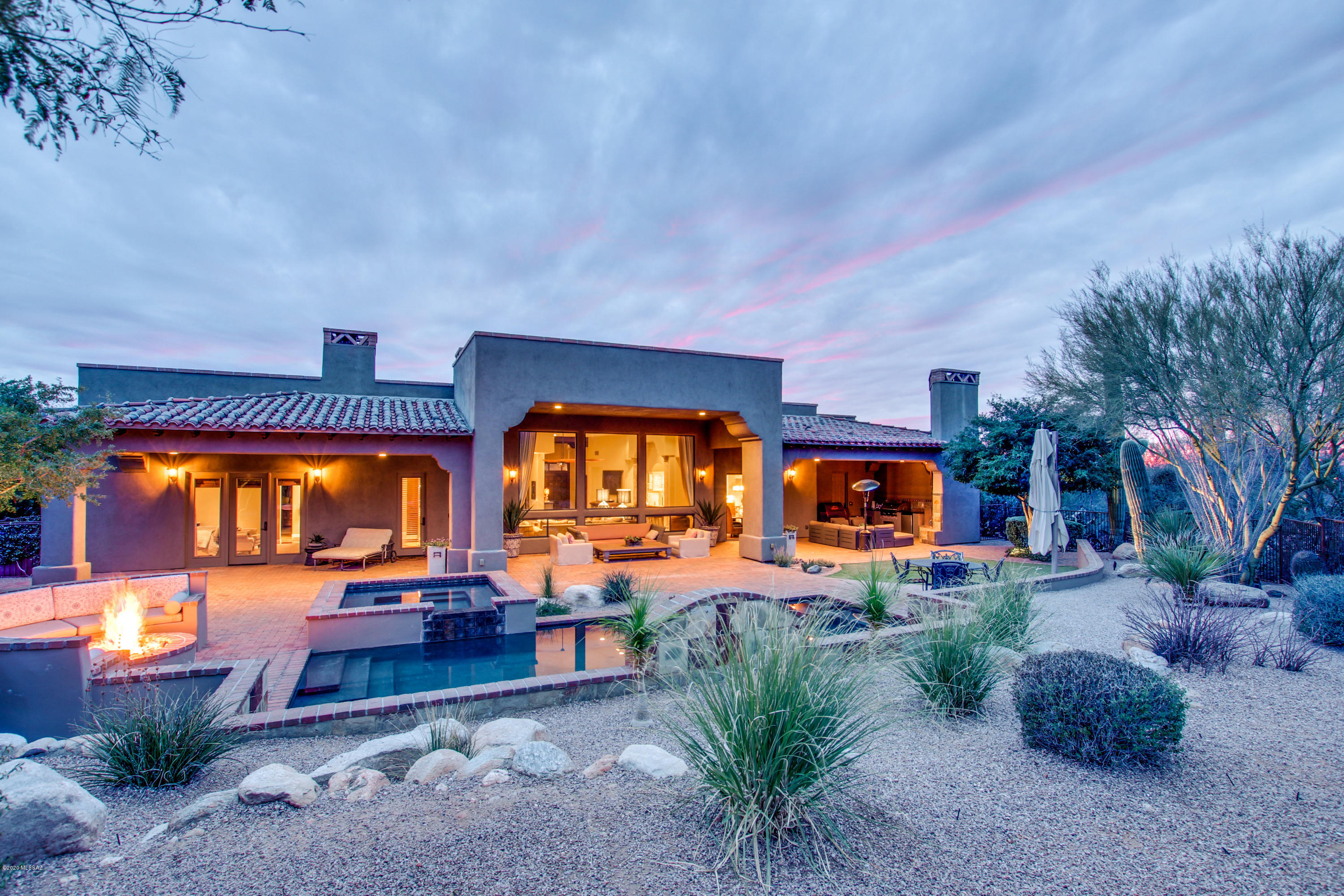 Gorgeous custom built home w/ amazing sunset and mountain views! This 5bd/4bth home sits on just under an acre of land and is in the sought after after Catalina Foothills School District. Open floor plan with large windows in the great room looking out to the mountain views and backyard oasis. The kitchen features silestone countertops, stainless steel appliances, a large island, breakfast bar, wine cooler, and much more! Perfect for the chef in the family! Wooden double doors lead into the luxurious master suite that features a cozy fireplace and access to the backyard. In the master bath there is a separate shower and garden tub, 2 vanities, and a huge walk-in closet. The back covered patio has a built-in BBQ and fireplace. Come by and see all this amazing estate has to offer!