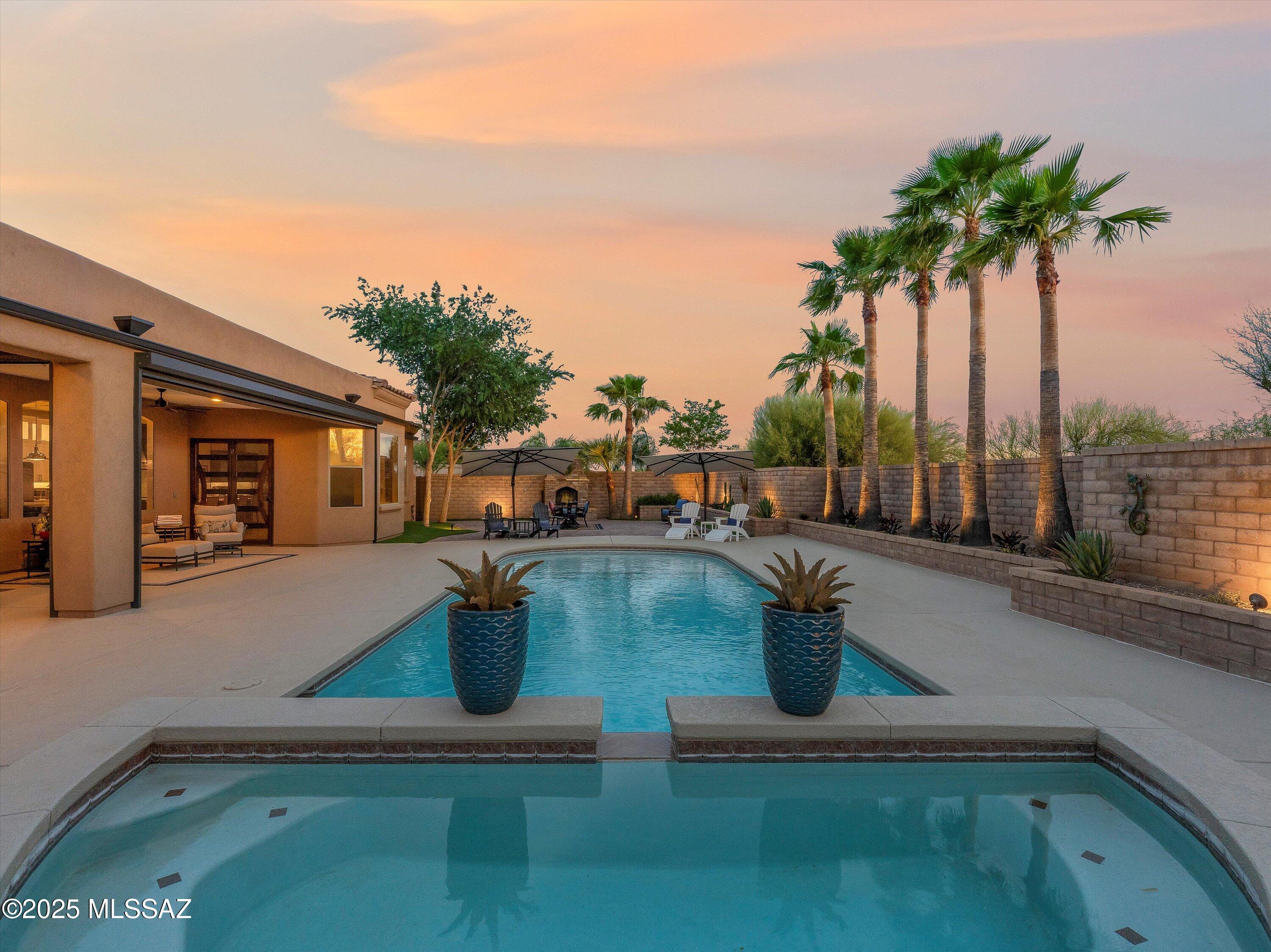 Welcome to a meticulously updated luxury retreat in the Tucson suburbs, where mountain views meet modern elegance. This exquisite home blends indoor comfort with resort-style outdoor living. Recent upgrades include new Limestone flooring, HVAC, water heater, and quartz countertops. See list of extensive upgrades. The chef's kitchen boasts a Thermador 48'' dual fuel range, twin Frigidaire fridge/freezer, 9x5 quartz island, pot filler, and new cabinetry. Enjoy a luxe primary suite, updated en-suites, and a stylish powder bath. Outdoors, relax by the stacked-stone fireplace, swim in the refreshing pool, or dine under the screened patio with rolling UV screens. Smart systems, new landscaping, and an 8' privacy fence complete this one-of-a-kind oasis. Located close to dining/shopping/schools