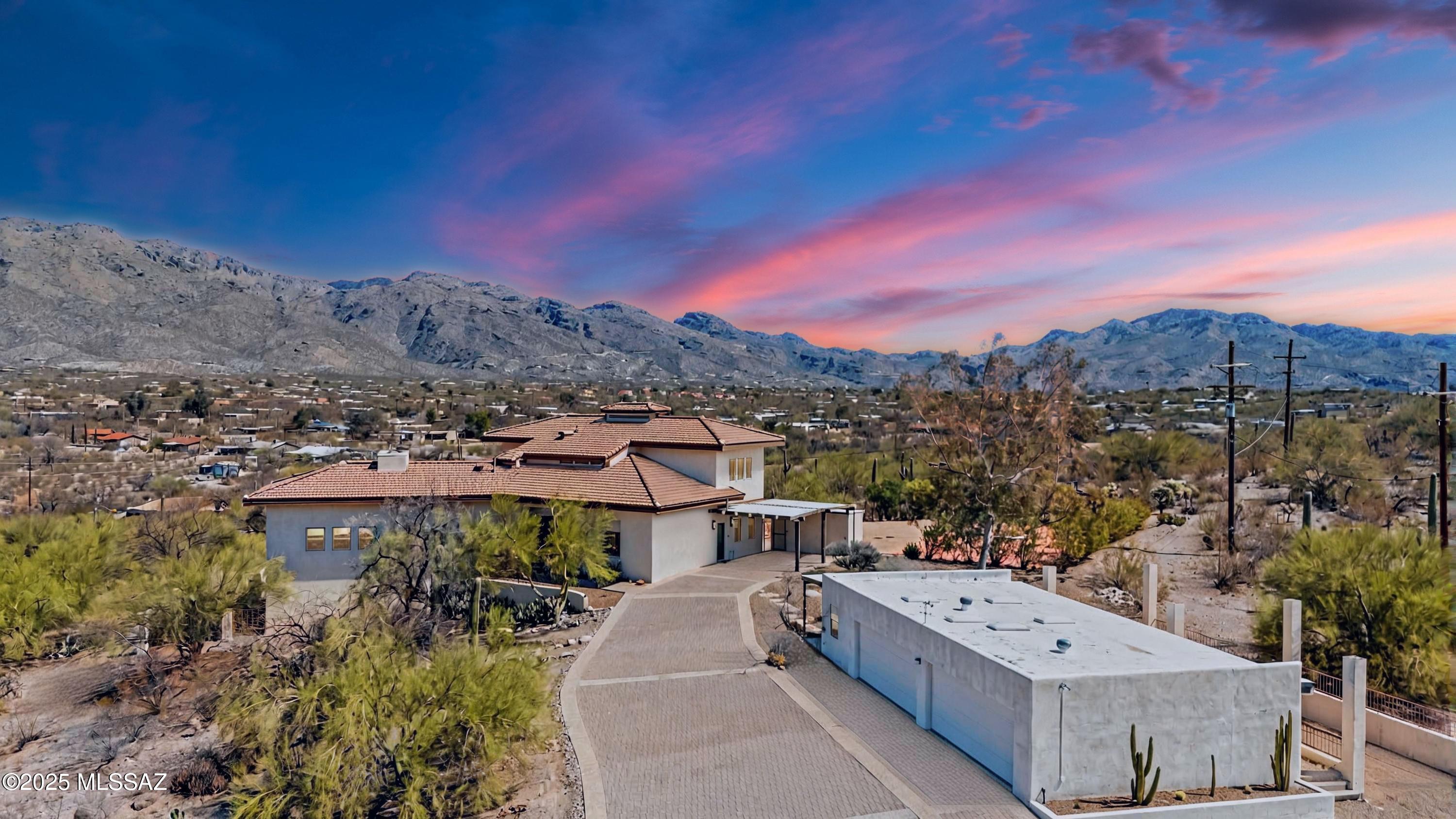 Amazing opportunity for updated 6,231 Sqft, 6 bedroom/4.5 bathroom, split floor plan, masonry stucco modern contemporary home that offers unparalleled luxury, expansive living spaces, and breathtaking panoramic mountain views and city skyline. Boasts a refreshing pool, heated spa, two full kitchens, dedicated gym, lighted paved basketball/sports court, new custom metal balcony, patio and deck, massive 1,407 SqFt 4 car finished garage/workshop with power, dedicated RV storage space and RV 50 amp hookup. Perched on an elevated 3.37-acre lot, horse property with no HOA, this is the perfect home for those seeking privacy, comfort, and room to grow. This incredible property is being offered below the recent $1,550,000 appraisal, providing a rare opportunity to own a luxurious, updated home in Northeast Tucson.
Welcome to this meticulously remodeled home offering a perfect blend of contemporary design and high-end upgrades. With extensive renovations completed from 2020 to 2025, this home is truly a showpiece. Nestled in the highly desirable Telesis Terrace, this property features both exceptional interior and exterior improvements that create a luxurious, comfortable, and modern living space.

Exterior features:  Long Paver Driveway: A beautifully landscaped, long paver driveway leads you to the home, offering a grand and inviting entrance with plenty of space for guests.

New Tile Roof (2020): Enjoy peace of mind with a newly installed, durable tile roof that adds a sleek and modern touch.

Refreshing Pool & Heated Spa: Relax and entertain in your private backyard oasis, featuring a stunning pool and a heated spa, both designed for ultimate relaxation. Smart Pool Equipment (2021): enjoy ultimate convenience with new pool equipment, smart app lighting, and spa control for effortless relaxation

Upgraded Septic System (2022): Includes a larger capacity septic tank and new leach fields to ensure efficiency and reliability.

New Custom Steel Construction Balcony, Patio & Deck (2025): Enjoy outdoor living with a newly constructed metal balcony with Trex decking and patio, all designed to maximize views and functionality, perfect for entertaining.

Updated Front Entrance (2021): A newly designed front entrance featuring updated stucco, lighting, and a beautifully landscaped walkway enhances curb appeal.

Lighted Paved Basketball/Sports Court: Perfect for active lifestyles, this court allows for year-round fun and fitness.

Massive 1,407 SqFt Finished Garage/Workshop: Ideal for car enthusiasts, hobbyists, or those needing extra storage for their toys, this 4-car garage features power and ample space for your projects. 

Dedicated RV Storage with 50 Amp Hookup: Park your RV with ease in the dedicated storage space, complete with a 50-amp hookup for convenience.

Horse Property: With over 3 acres of land, this property is perfect for equestrian enthusiasts.

Interior Features: Main Floor Design & Remodel (2020-2021): This home boasts an extensive main-floor remodel, elevating every room to meet the highest standards of design and functionality.

Main Floor Updated Gourmet Kitchen: A top-to-bottom redesign with custom European-style cabinetry, modern lighting, a large island with seating, waterfall-edge quartz countertops, and a stunning Alex Turco feature backsplash. Equipped with SubZero Wolf appliances and an oversized pantry, this kitchen is a chef's dream.

Two Full Kitchens: Perfect for hosting or multi-generational living, the home features two fully equipped kitchens with high-end appliances, ample cabinetry, and counter space.

Primary Bedroom & Bathroom: A complete transformation includes a custom oversized shower with contemporary glass tile, custom cabinets with solid-surface Dekton countertops, LED Bluetooth-enabled mirrors, and a custom-designed walk-in closet by California Closets.

Dining Room: The dining room features a large buffet cabinetry with quartz countertops, ideal for entertaining, and custom cabinets for storage and display.

Living Room: A remodeled living room with a contemporary fireplace, custom stone tile feature wall, and stylish lighting makes this space perfect for relaxation and entertaining.

Entryway & Staircase: The front entryway has been reimagined with an open flow and a statement steel and glass front door. The staircase has been redesigned with hardwood flooring and contemporary steel railings.

Energy Efficient Double Pane Windows: This home boasts updated energy efficient double pane windows throughout with real wood trim.

Laundry Room: A spacious laundry room with custom cabinets, a large utility sink, and resilient solid-surface Dekton countertops for durability and ample storage.

Flooring: New wood-look tile plank flooring throughout the main floor adds warmth and style to every room.

Doors & Lighting: New exterior doors and upgraded LED ceiling lighting with 42 can lights throughout the main floor for an extra touch of brightness and energy efficiency.

Dedicated Gym: Stay fit and healthy with a dedicated gym space, fully equipped for a range of workouts.

Bottom Floor Bathroom & Kitchen: The bathroom has been modernized with a custom shower and tile, along with updated fixtures. The kitchen features new stainless steel appliances.
Enhanced Lighting: Additional ceiling LED can lights have been added in every room, creating a bright and welcoming ambiance.

Zoned HVAC System: Four new HVAC units have been installed, ensuring modern, efficient climate control (1 in 2022, 3 in 2023).
Tankless Water Heaters (2015-2016): Enjoy endless hot water with the energy-efficient tankless water heaters installed throughout the home.

Whole House Water Softener (2017): A premium water softener system ensures that every tap provides fresh, soft water.

Termite Prevention Treatment performed in 2024 with annual inspections over 5 yr warranty.

Your Dream home awaits!! With extensive upgrades, unparalleled outdoor amenities, and breathtaking views, this home is a true updated masterpiece. Whether you're entertaining, relaxing, or enjoying your own private retreat, this property offers it all. Call to make your appointment to view this magnificent home today!!