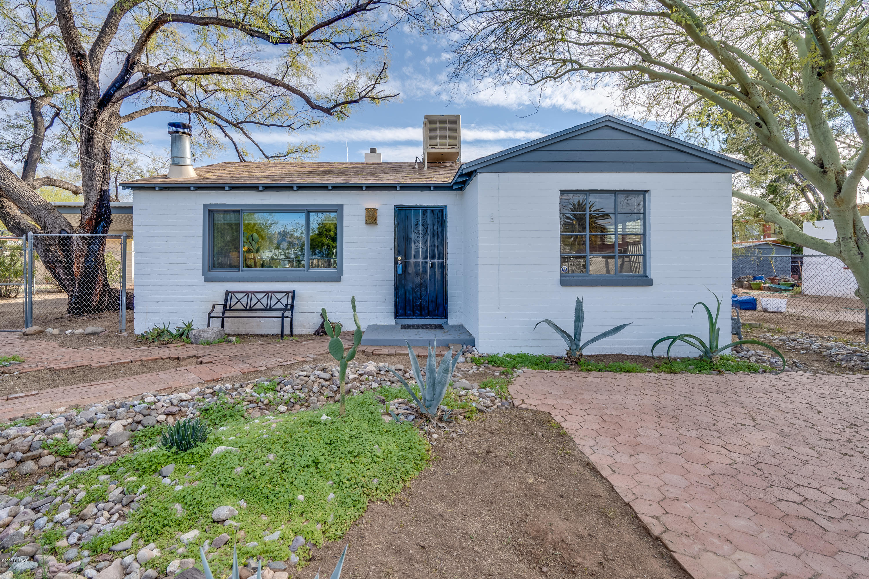 Charming 1947 bungalow with updates on a quiet street near the university! Masonry built on generous R2 lot, mature trees and vegetation line the exterior that create a fine desert oasis. Large two bed, one bath, plus ''bonus room'' has 1250 sq ft. Recent UPDATES include bathroom, fresh paint inside and out, new flooring and counters in kitchen. This cute home is move in ready or rental ready! Exterior spaces include walled in yard and covered patio space, large two-car carport and utility shed all with the low care you want. New roof shingles in 2019! No HOA and all close to some of Tucsons best dining, shopping, walking, and biking. Make an offer today!