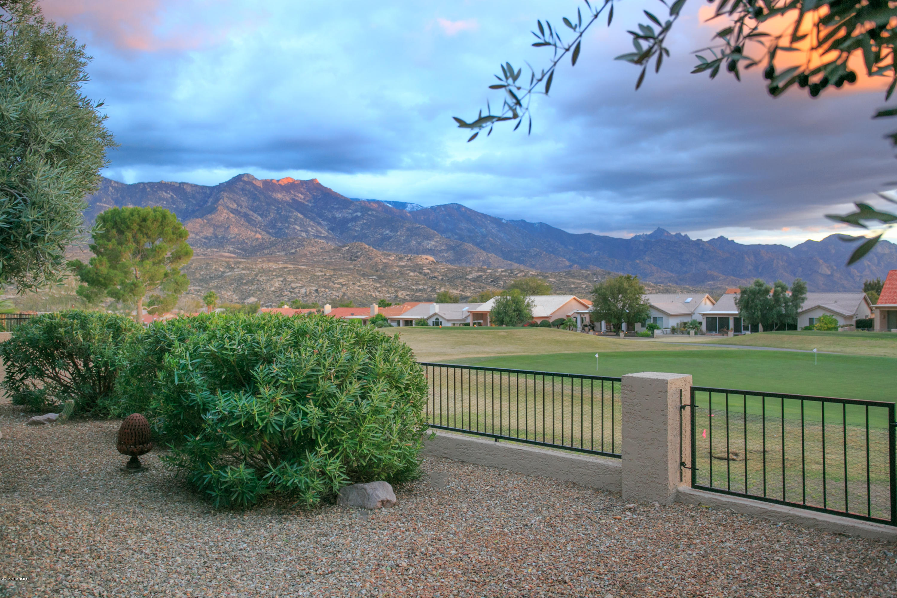 Stunning, highly customized & upgraded Cambria model with magnificent mountain & golf course views! This spacious, single story home features a 400 sq ft Studio/Casita w/kitchenette & bath, plus golf cart garage, beautifully redesigned kitchen w/gorgeous chiseled slab granite, SS appliances, 5 burner gas stove, impressive pendant lighting, custom cabinets, open/oversized shower in master bath, granite counters & cherry cabs, solid red oak hardwood floors in main home and master bedroom, 2 fireplaces, large walk-in storage closet, all new Pella windows & doors on back of home, custom designed stained glass piece in dining room window. Incredible backyard oasis w/beautiful granite water feature, fully covered patio extended w/ramadas & located on the 5th hole of the Tucson course!