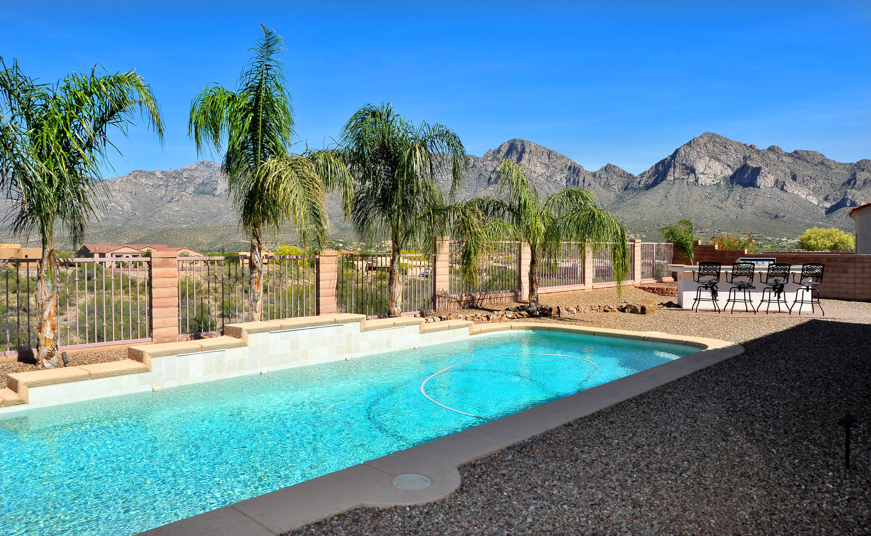 Stunning Catalina Mountain range views from the elevated, east facing patio & lot overlooking a  desert common area. Immaculate, better than new home offers 4 Br's, 3 full ba's & a 3 car garage. Oversized greatroom with wall of glass opens to a gourmet kitchen with granite counters & brand new 3 door stainless steel refigerator & gas cook top. Inviting court yard entry, clear view plantation shutters, solid porcelain tile & bamboo floors in BR's, premium security/screen doors, sunscreens, surround sound. Entertainers backyard with extended patio area, pool & separate outdoor kitchen with BBQ, ref etc. Large master suite features fireplace & sitting area, luxurious, spa like bath with glass walled shower. Great gated community, close to everything. Beyond exceptional in every way!