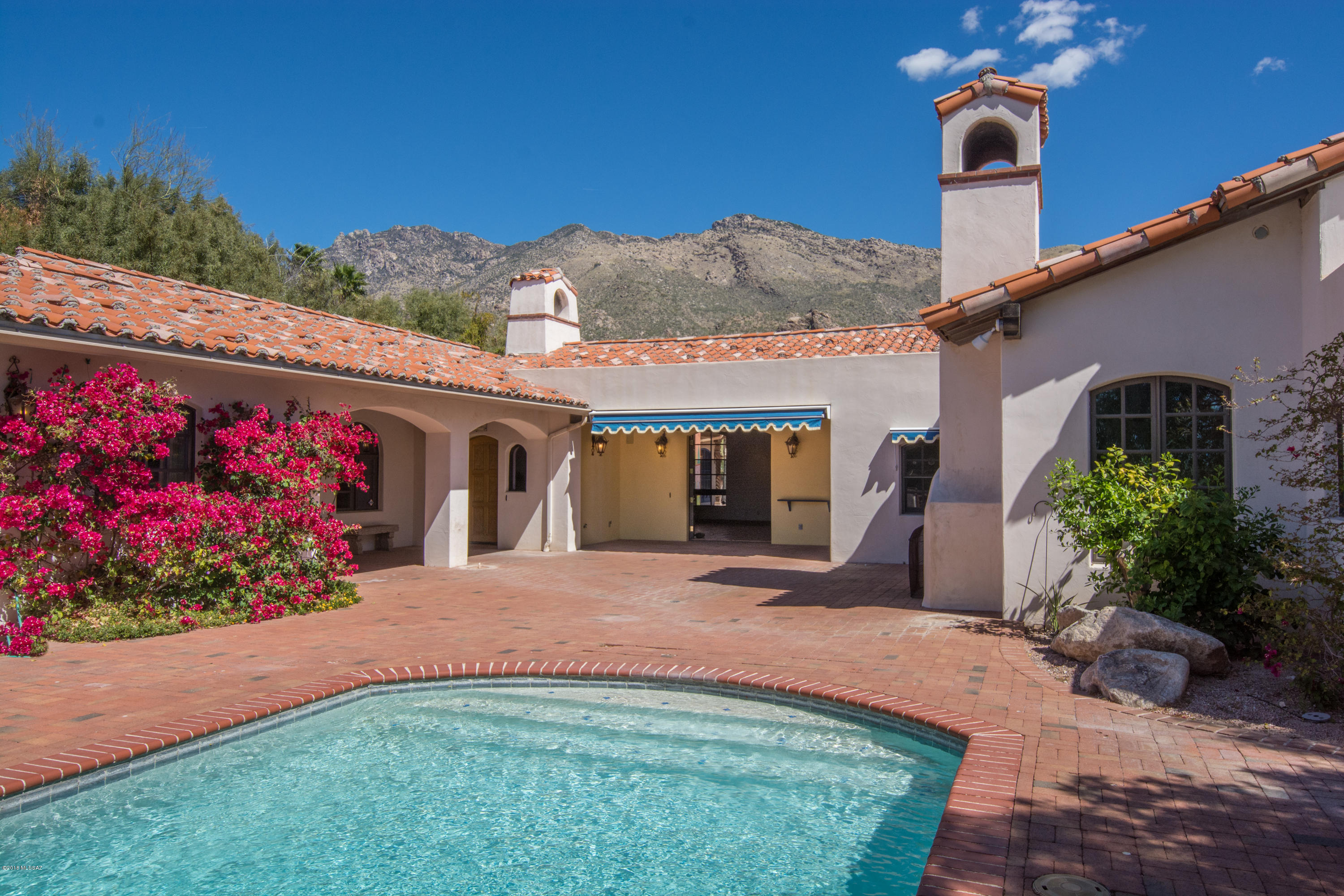 ESTATE TRUST reduced another $51K to SELL NOW! Mediterranean influenced w strong affinity for the past:tile roof, archways, beams, soaring ceilings, attention to detail, hand-painted charm BUT a very flexible floor plan that is both calming + promotes an indoor/outdoor lifestyle. Gravitate to the south facing entry courtyard for the house & guest house; whether it is breakfast in the courtyard loggia, cocktails at the pool, lounging in-front of the fireplace listening to the water cascade at the pool with a glass of wine to extend the evening, or using the Mirador for stargazing! The off-white walls are perfect for art & tranquility. This house has texture, is creative, filled with light, stunning wrought iron work+mountain views all on 1.1 acre in a small gated community of custom homes.