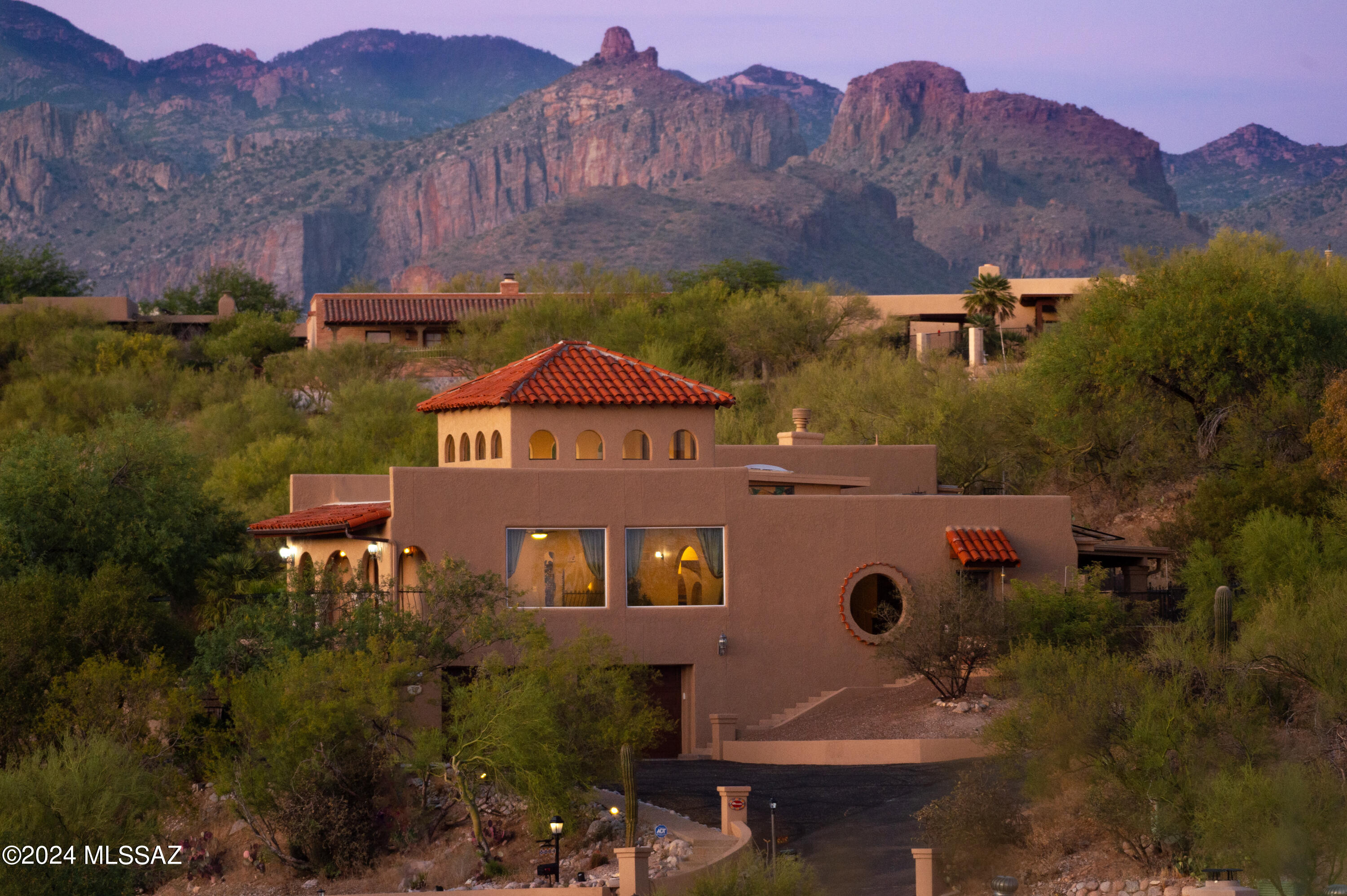 Welcome to your dream home in the heart of the Catalina Foothills! This exquisite Spanish Colonial residence offers the perfect blend of timeless charm and modern luxury, with the added allure of breathtaking mountain and city views. Boasting 5 bedrooms, 4.5 bathrooms, and a sprawling 4,413 sq ft of living space, this home is a true masterpiece.
As you step through the wrought-iron entry gate, you are greeted by a beautifully landscaped courtyard adorned with a captivating fountain, setting the tone for the elegance that awaits inside. The grand foyer opens to a spacious living room with large windows that not only bathe the room in natural light but also frame a stunning views that can be enjoyed from the comfort of your home.