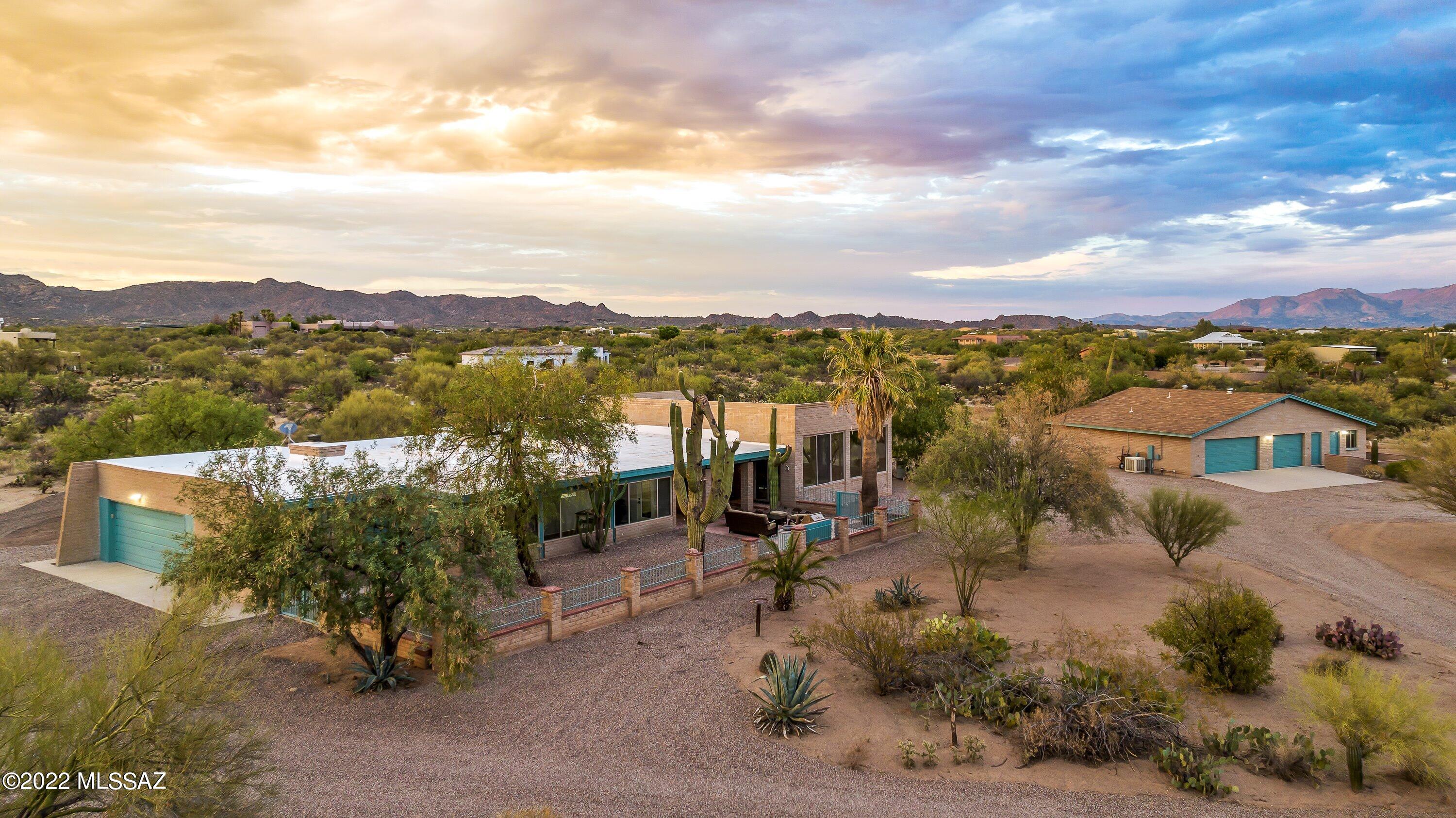 Bring your offer! Unique and full of charm nestled amid an 8.4acre saguaro studded desert lot with panoramic Mountain views, this Gorgeous Territorial style compound is a true dream for anyone who loves Aviation, Horses, Year- round swimming, Seclusion, extra Garage spaces (a total of 5) or a vast Workshop plus a private space for guests. Located in the prestigious La Cholla Airpark, a private residential Airpark at the foot of the Tortollitas in Oro Valley, this solid masonry brick home exudes class and is sure to be the envy of all. A private automated gate greets you and a long gravel driveway leads you to the main home. True Tucson charm greets you with whimsical porches and Saltillo floors. Large picture windows create the feeling of seamless indoor/outdoor living while mesmerizing 360degree mountain views provide a sense of immeasurable serenity. A perfectly sized 2324sq ft 3Bed/2Bath, 2-car garage main home with rows of windows and dual, yet flexible, living/dining areas, elegant Chef's kitchen w/marble backsplash and quartz countertops, pristine and shiny saltillo tile throughout, walk-in pantry/craft room/laundry room and an enclosed 1235sq ft indoor swimming pool and spa!! Yes, year-round swimming in a temperature-controlled room with enormous sliding windows. Access your pool directly from your expansive Primary suite complete with stylish Bathroom w/spa-like finishes, modern Barn doors and walk-in closet. Enjoy time with family and friends under the shade of your covered porch or cool off in the pool! Be captivated by ever-unique sunrises and sunsets from anywhere! Did I mention every window has a view? Yes, every window! The front living room is bright and welcoming as is the entire home! Quaint wood-burning FP is sure to bring warmth during our chilly nights. Open floor plan allows ease of entertaining and transitioning within living areas.
Stroll down to the adjacent building where you will find a classy 676sq ft Guest studio with kitchen and private bathroom. With views mirroring the main home's, this space can also serve as a home office/business, art or music studio, whatever your heart desires. Perfect for multi-generational living as well. Also, you will find a magnificent heated/cooled 3-car garage plus workshop and storage! Guest home can be expanded to add a bedroom by using some of the garage sq footage.  Looking for a horse property? Bring your horses! A tack room and stall with covered awning are just steps from the workshop building- just need to add the corrals. Strolling around on your property will always feel as if you are at a trailhead. The home has been lovingly and tastefully updated to preserve original charm. NEW ROOFS on all three structures Feb 2023- main home, workshop/GH and tack building.  Beautiful touches throughout, new windows/doors, new kitchens, new bathrooms, lighting, fresh paint, new walk-in pantry/laundry, incorporated AZ room as a true year-round livable space and more. A true desert dwellers abode is here for you to have all you need and more. Build the hangar of your dreams and a taxiway with runway access towards the back part of the lot.  The Airpark's common area is 35acres- owned by 120 shareholders. The Airpark is set on 1.5 sections, or about 1000 acres. All lots are a minimum of 7 acres. 4,400'x44' Paved & Lighted Runway, 100LL Aviation Fuel Available, ID-57AZ
Shopping and dining are within 8 minutes from your home. I-10 access within 15 minutes. Close proximity to Stone Canyon. Enjoy all Oro Valley and Marana have to offer. Oro Valley Water- No well!!!
** All structures add up to about 6000sq ft of solid masonry construction** See Floor Plan
***Home appraised at $1,150,000***