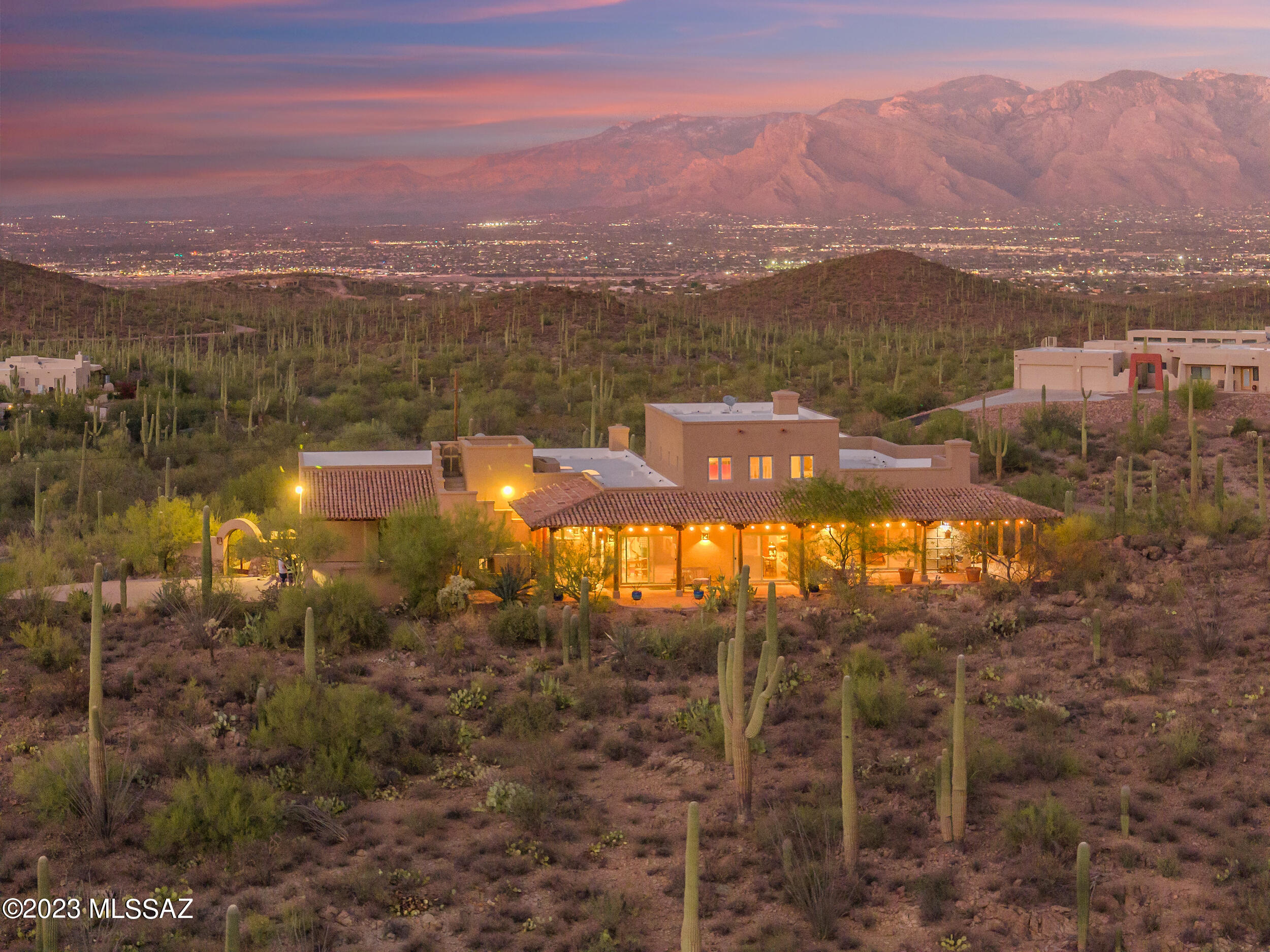 Perched high on a hilltop with 360 degree views, this masonry-built home with a Hacienda-style courtyard entry welcomes you with an immersive desert experience. Uncompromising privacy and nature abound with quick access to nearby Sweetwater Preserve, Tucson Mountain Park, Saguaro National Park and The Desert Museum. The desert flows naturally throughout the residence with views and patios in every direction so you can experience the abundant wildlife and saguaros across the rolling landscape. As you pass through the beautiful double door entry, you'll be greeted with an extensive list of features such as three Rumford Fireplaces, separated living quarters for your guests, custom wooden doorways, and brass fixtures. Modern amenities and appliances are found throughout, including sub zero fridge, Casablanca fans, undercabinet lighting, and a large kitchen area open to the formal dining space, with integrated butcher block on the oversized island. 
Intrigued? How about a secret stairway behind a bookshelf that takes you up to the loft office area, with dramatic views from which you can draw inspiration, or distraction. Make this your home and watch the sun rise and set, the monsoons come and go, and the stars light up the Tucson sky.