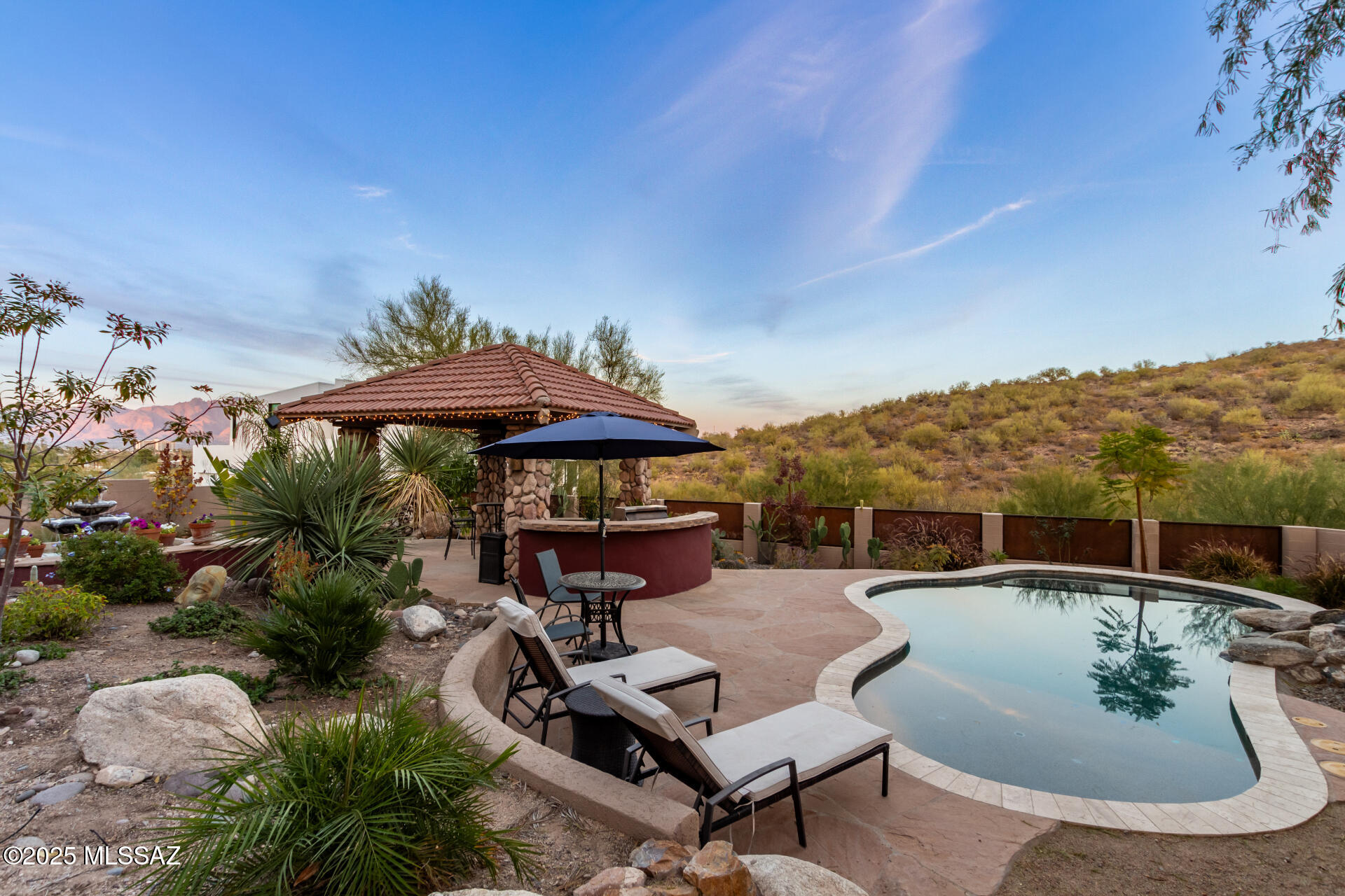 REDUCED FOR IMMEDIATE SALE! SPLASH INTO SUMMER! Welcome to Resort Living, Truly a Desert Oasis in the ''Old Pueblo'' w/Private Pool, Hot Tub, Ramada, Solar for pool.  NEWLY INSTALLED Engineered Wood Flooring! Property backs-up to Sentinel Peak Park! Surrounded by Mtn, City, Desert Views. Property is 3 Lots exquisitely landscaped, Lush Pond, Water feature, Fountain & Ramada! 2story 3/3, Two Primary Brs 1 upstairs/1downstairs with access to stunning backyard. Cozy FP in Loft area, High Ceiling and Beautiful Light, and Warm Floor Plan. Sweeping City lights from Upstairs Balcony. Incredibly convenient to  access to Downtown dining & shopping, 10 minutes to Sunlink Street Car, Backs up to Wash, enjoy walks and beautiful scenery!  Truly a UNIQUE PROPERTY YOU HAVE TO SEE!