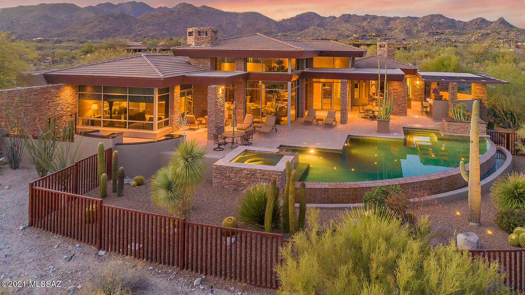 This timeless Frank Lloyd Wright inspired contemporary home embodies quality & craftsmanship at every turn. Located in the prestigious gated community Stone Canyon on 2 elevated lots w/ 360degree views sits this rare gem designed by So. AZ's premier architect, Kevin B. Howard. This sophisticated 5,488-sq. ft. home offers 5 ensuite bedrooms including separate guest casita, exercise facility, & stunning resort-like backyard. Enter thru custom rustic metal/glass doors into captivating living room w/ full height windows & 25' ceilings, showcasing panoramic Pusch Ridge views. Entertain in backyard that naturally projects from the indoor space w/ award-winning 7' deep infinity-edge pool, spa, & outdoor kitchen w/ pizza oven. Master Ste is the perfect retreat w/ FP & private access to patio.