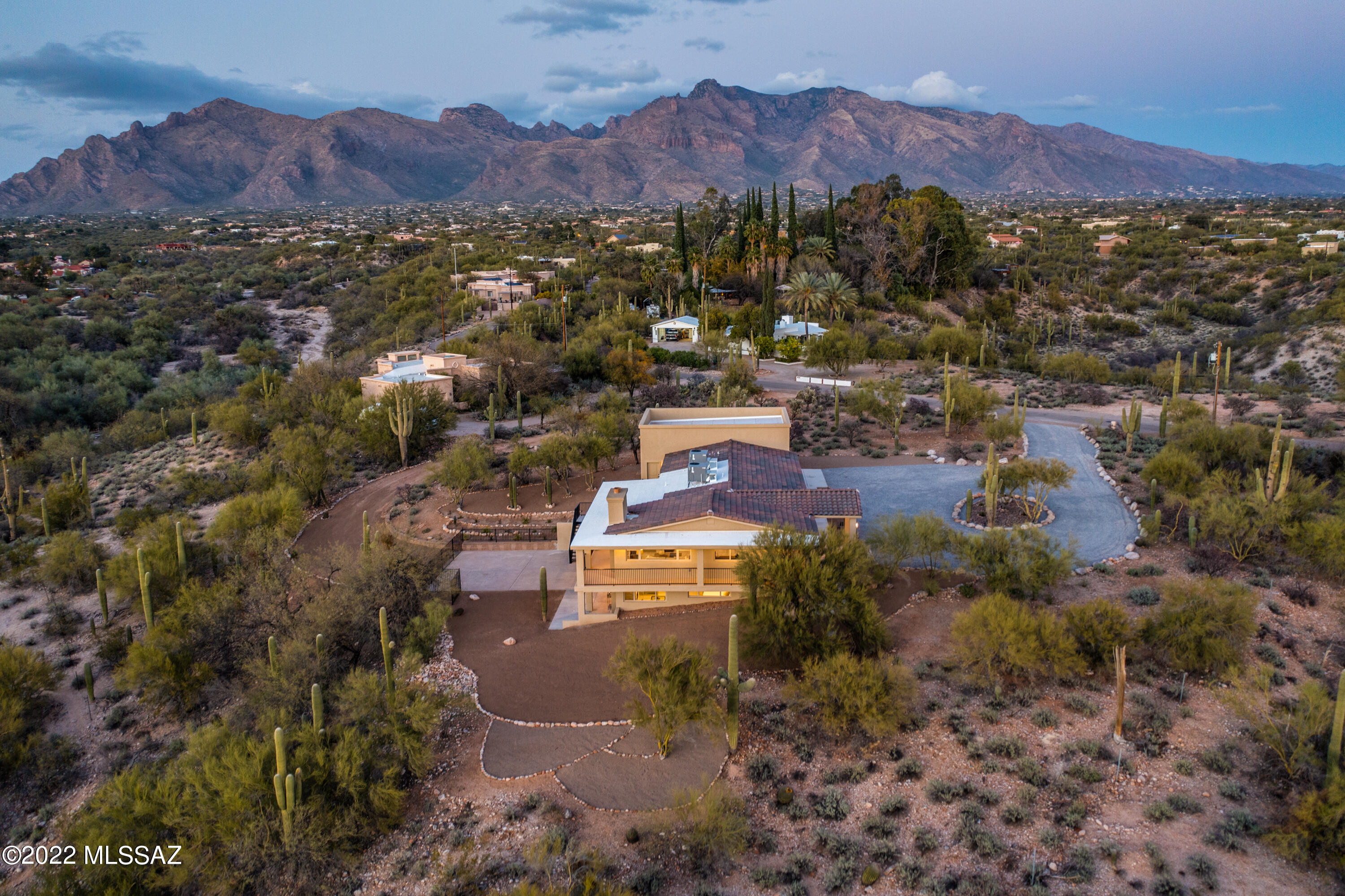 This private hilltop home has panoramic views with city lights, mountains and gorgeous Arizona sunsets. It's studded with 75+ saguaros. All of this is enjoyed from both the interior and the expansive patios. The master suite is a retreat. As you enter the suite you'll find a room ready to be your perfect office, library or gym and a quiet sitting area that opens to a romantic space with beamed ceilings, fireplace, and windows that frame the sunsets. The spacious bathroom has an elegant freestanding tub and dual shower. The main living area is incredibly flexible and offers 3 areas pre-wired with cat5 & RG6  for prime TV and computer performance. The kitchen features quartz counters that grace long expanses of custom cabinetry. The 4car tandem garage is fully finished and well insulated