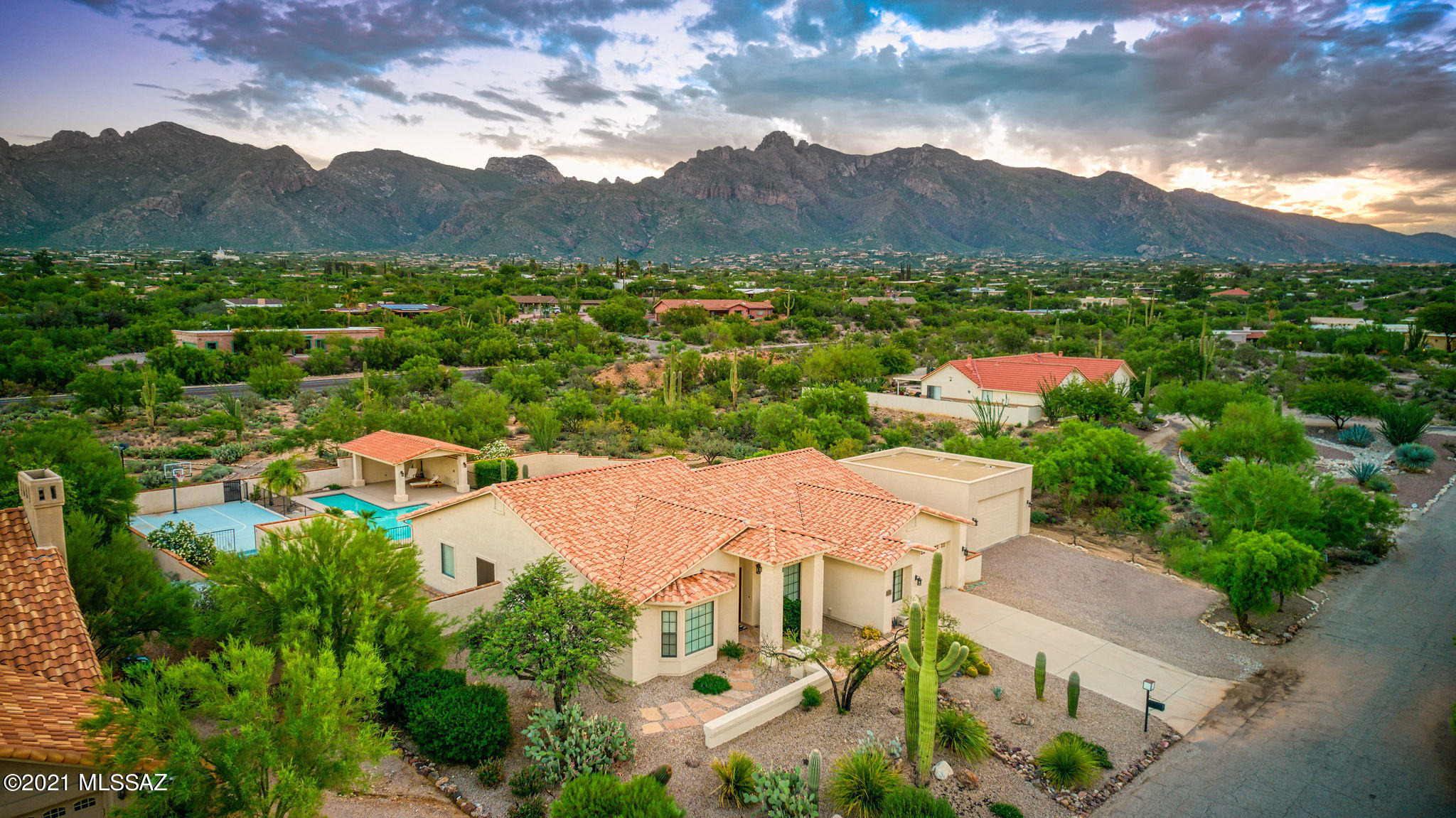 Fantastic opportunity for luxurious 2,549 SqFt four bedroom and three bathroom modern contemporary on elevated .96 acre premium lot, four car garage in desirable Shadow Hills community in North Tucson. Resort like manicured backyard includes solar heated lap pool, spa, lighted basketball court, two covered patios, green grass yard, cactus garden, finished landscaping with omnipresent Catalina Mountain views surrounded by masonry stucco privacy wall.