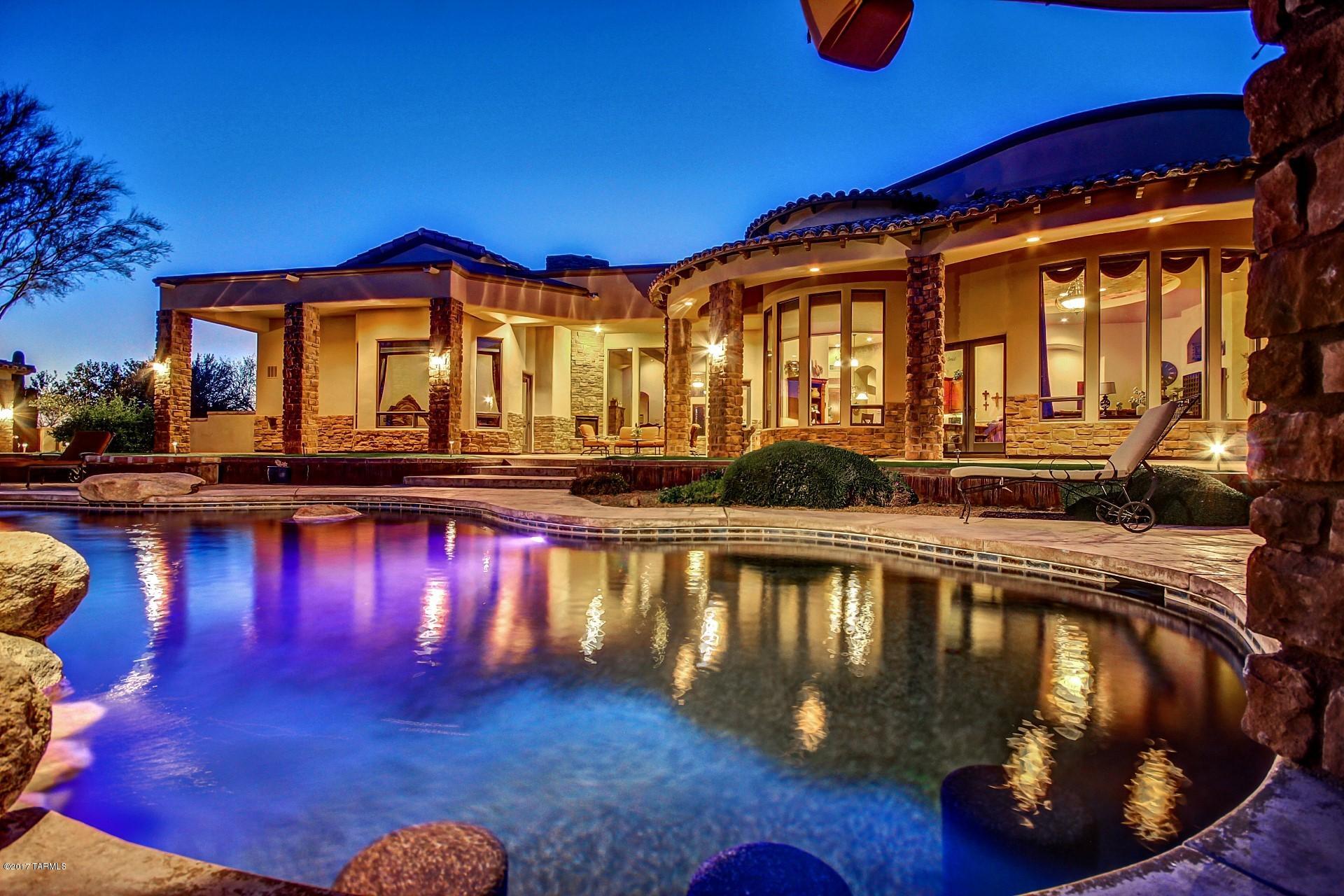 Amazing 7000 sq/ft custom home resting on 3.77 acre lot! Borders on 600 acres of State Land. Gated Neighborhood! Amazing Mountain Views! Gorgeous Outdoor Oasis. Perfect for entertaining. Sparkling Pool with Spa, Swim up bar, Outdoor kitchen, fire pit and even a putting green. Home features 13 ft/diameter Boveda ceiling, vaulted, wood beams, Spacious rooms, (games room and both dens can be converted into bedrooms) Beautiful chefs kitchen with granite counter tops, Knotty Alder doors and Windows, Wine Fridge and Stainless Steel Appliances.  Elegant master suite with Fireplace, jacuzzi tub and huge walk-in closet. A total of 4 Fireplace! Beautiful Guest house is 2 bed 2 bath with single car garage. Shared well for low cost water. A MUST SEE!