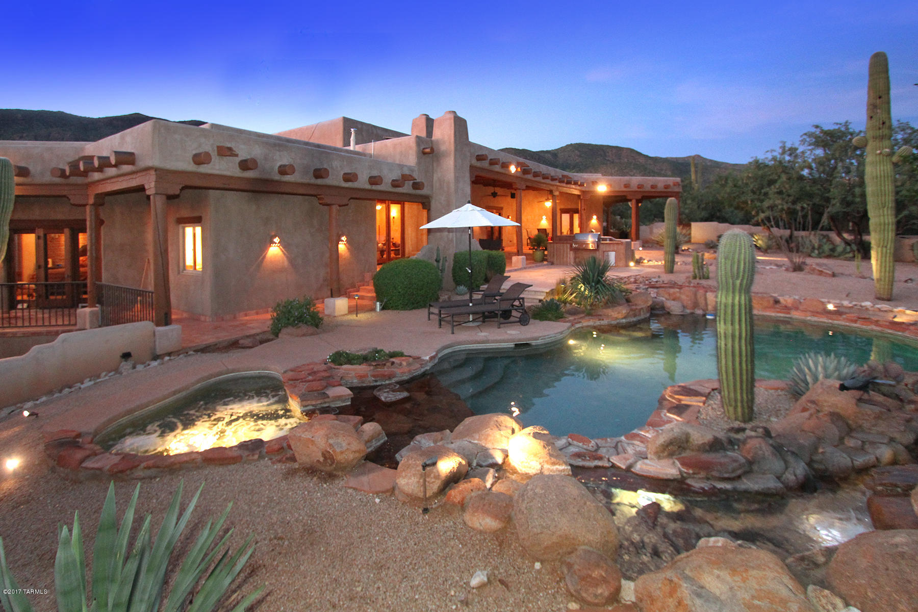 Enter through charming flagstone courtyard to this stunning Ray Birch custom built home located on a private cul-de-sac lot in a small gated enclave of 9 custom homes in The Sanctuary. This authentic Santa Fe home boasts impressive viga beam ceilings w/Saguaro ribs, Saltillo tile flooring, beehive FP, hand troweled imperial plaster walls & forged iron light fixtures throughout. Living room windows showcase panoramic mountain views. Recently remodeled kitchen features Sub Zero/Wolf SS appliances w/3 new wine fridges, beehive FP & quartz countertops. Private master suite w/beehive FP, walk-in California closet & Jacuzzi tub.  Flagstone patio w/beehive FP opens to pool/spa w/rock waterfall and 42'' Lynx grill. This home is bordered by protected open space adjacent to Sabino Canyon.