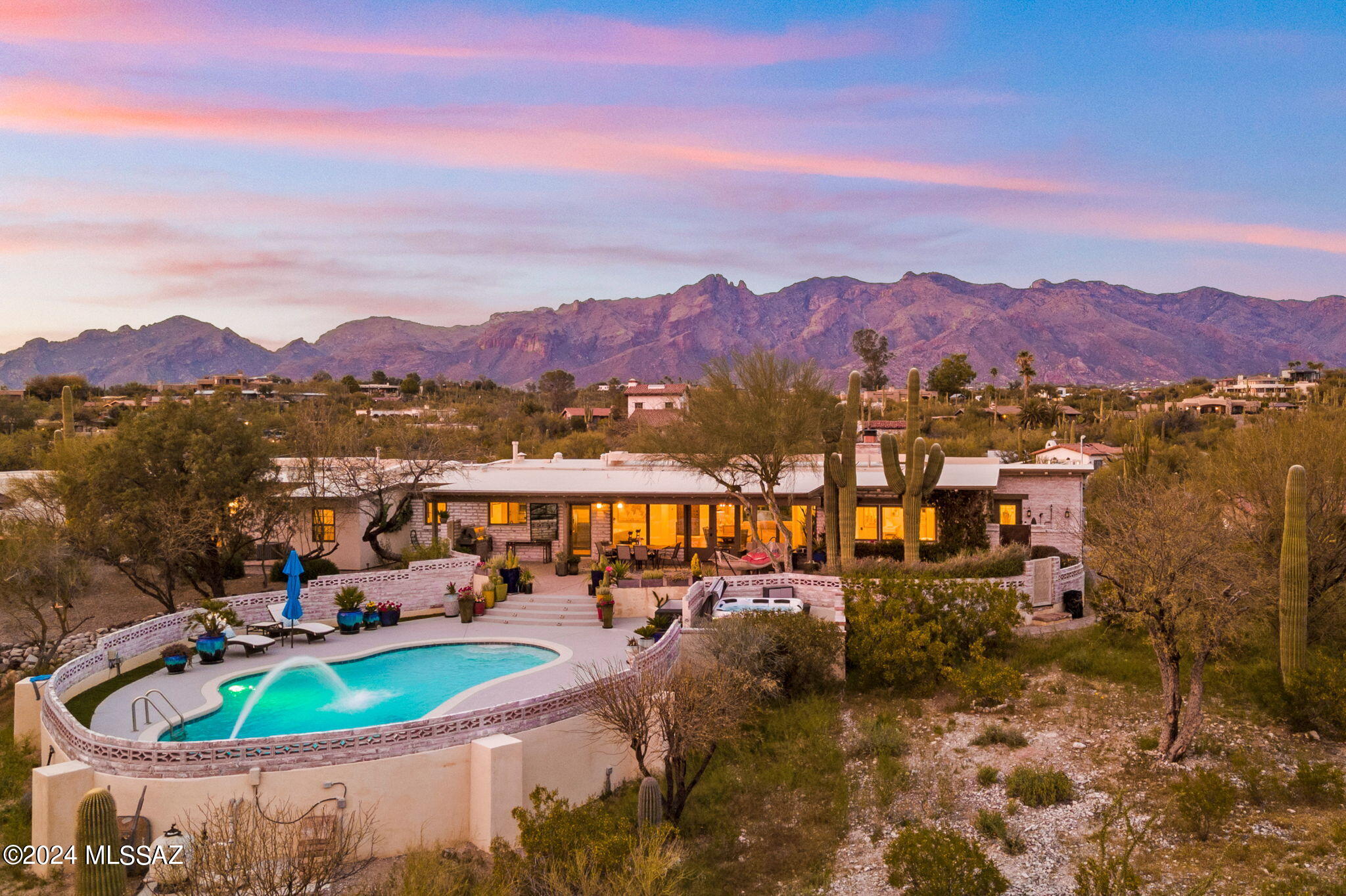 Top of the World! Perfectly situated on a breathtaking, hilltop lot, this quintessential Foothills home sets a new standard for comfortable elegance and authentic Tucson feel! Welcome home via private paver driveway, you arrive to stunning curb appeal, distinct pride of ownership, and a one of a kind sanctuary! A  seamless blend of timeless masonry construction, tasteful and well thought out design, and signature location make this home one of a kind! While you are in the center of it all, you feel a world away! Walk in to soaring ceilings and refined elegance with unrivaled mountain and city views! From every single room, showstopping views and sparkling natural light help to engage the senses to the distinct beauty of the desert surroundings! You cant help but feel a sense of connection and comfort here. The chefs kitchen adorned in quartz and overlooking the city is ready to support your most daring epicurean adventures or simple comfort creations. The primary suite is a retreat with walk in closet, spa like bathroom with free standing, soaking tub, office area, and private outdoor shower. The split floorplan allows for everyone to feel comfortable and at peace in this special home. The backyard is an exquisite example of the good life with sparkling pool and spa, deep covered patio, and city views galore! Don't miss the charming front yard, wood floors, newer HVAC, and smart home features. Truly a special opportunity here! Welcome home!