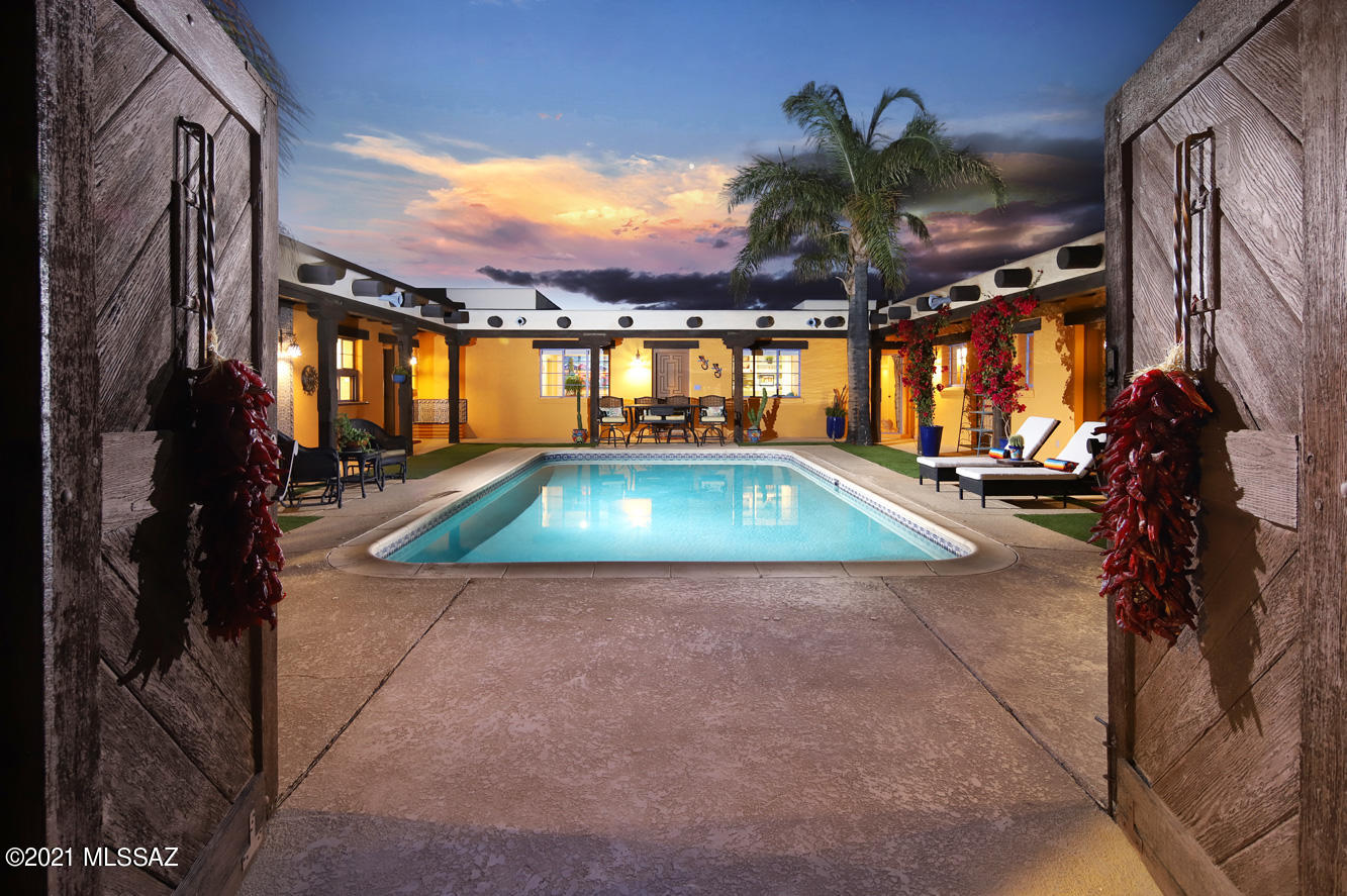 A delightful hacienda-style desert oasis in the Tucson Foothills, with a lush central courtyard featuring a serene turquoise pool, wrap-around patio and views of the Santa Catalina Mountains from the entire retreat, abounds with ''old Pueblo'' warmth and charm mixed with stylishly renovated interiors.  Views of the well-known landmark of Finger Rock in the Catalinas are seen from the courtyard and the many large windows throughout this naturally lit unique home. Enter the property through a private electronic gate and up a long drive for complete privacy on 1.24 prime acres. Dramatic wooden doors with forged hardware provide entry to the courtyard with swaying palm trees, bright bougainvillea and green turf accents and a handsomely carved front door surrounded by Mexican tiles. It's a home constantly filled with natural light, which boasts pecky-wood ceilings with vega beams, and Saltillo and porcelain "wood"- plank floors. In the expansive great room, relax by the handsome pueblo-style fireplace with a long hearth surrounded by bookshelves, and in the dining area with a handsome mid-century modern chandelier, while enjoying mountain and courtyard views on one side and lush desert views on the other side. No views of any neighbors! The newly renovated kitchen is any cook's dream, a well-lit ample space with stunning richly-shaded thick granite counters, windows opening to the courtyard for serving snacks to those poolside, high-end stainless appliances including a Thermador 4 burner gas cooktop and grill, tall GE Monogram side-by-side refrigerator and freezer and a 48 bottle wine fridge. Pullouts for lower cabinets, soft close drawers, separate pantry, and under-counter lighting, of course. A door leads to the "desert" side of the home, with a new meditative west-facing labyrinth perfect for walking at sunset, which the owners have described as "an exercise in self-healing".  The guest room is cleanly contemporary, with a walk-in closet outfitted with built-in drawers. An "Arizona room" overlooking the courtyard could be considered a library/study, a terrific spot to sit on the built-in lounge/sofa to read or watch the monsoons roll in on a summer day. Another room on the way to the master suite provides space for an office or exercise room. A large laundry space with storage is nearby.  The Owner's Suite provides sweeping views framed by saguaros of the Catalinas and Finger Rock to the north, and of city lights and our southern mountain ranges on the other side. The Owner's Bath is a luxe retreat with marble counters and make-up seated area, a graciously curved stand-alone tub, a huge glass-walled shower with two fabulous showerheads, and a fun little crystal chandelier. There's a door to the courtyard and more gorgeous views of mountain peaks. A walk-in closet is nearby. Two additional bedrooms are separately accessed from the courtyard, with a shared jack-&-jill bath. One bedroom has a bee-hive fireplace, fabulous built-in kitchenette/bar area for making margaritas for the gang by the pool, and "dutch" wooden door for serving those margaritas on a relaxed weekend. This magical home is in District 16 for schools, and has easy access to the the best of Tucson shopping, services, restaurants and entertainment in both the La Encantada area and in downtown Tucson. The property is fully monitored by Ring security cameras, although it is in a very safe neighborhood. The owners report that the only noise is the occasional joyous laughter of neighboring children in nearby pools, the evening distant howling of coyotes and the wind brushing through the palm trees. Fabulous hiking and biking opportunities are nearby. Life in the Southwest could not get better! Furniture package may be available- please inquire.