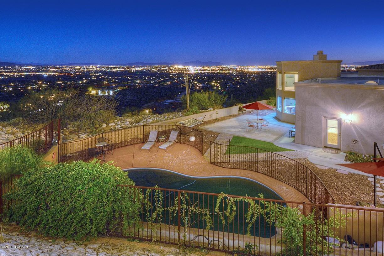 Incredible price for this stunning custom home, high on the ridge with views in several directions. Listed $300,000 below previous appraisal price! Open formal living and dining rooms. Family room open to spacious kitchen all with large windows to enjoy the vistas. All bedrooms are ensuite with baths. Luxurious master with his and her closets, fireplace, jacuzzi tub, walk-in shower, beautiful onyx sinks and a den and meditation/loft  area. Step outdoors to amazing vistas of Catalina, Rincon, & Santa Rita Mountains and sparkling city lights. Enjoy the fenced in pool, spa, BBQ area and covered porch.
Other amenities include Brazilian cherrywood floors, travertine, granite, and oversized 3 car garage with coated floors.