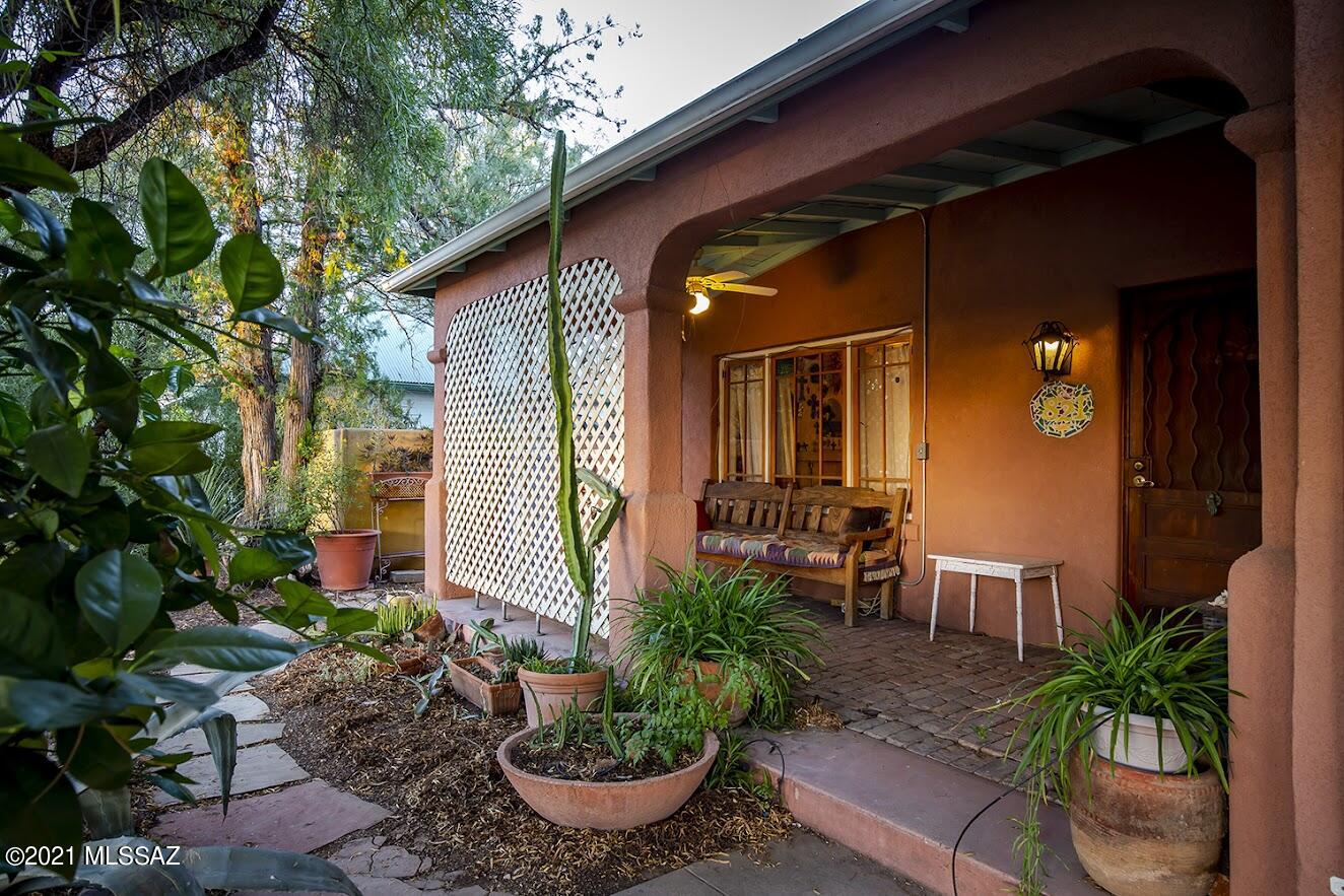 Step back in time! This adobe home is authentic as the day it was built, in 1916.  Charming and lovely, this vintage home is located in Armory Park, one of downtown Tucson's oldest neighborhoods.  Central A/C and a nearly new dishwasher, poured colored concrete countertops, bricked porch and kitchen area, high ceilings, two woodburning fireplaces... and on a .28 ac lot, which is like an artist's wonderland. Gardens, nooks, room to relax, create and play... or grow. Gorgeous outdoor spaces with lots of vegetation and trees.  The rolling gate hides the second half of this enormous lot, with room for a second house, a pool, a garage... the carport and chicken coop are there already. Seller has lived and created here for 30+ years, so charm abounds. A rare treasure, in the truest sense.